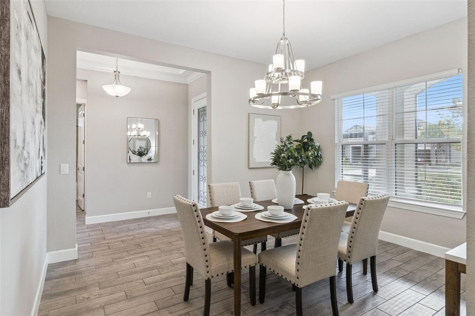 Separate dining room with elegant chandelier, neutral finishes, and natural light. - 4108 VIA TOLEDO CT, POINCIANA