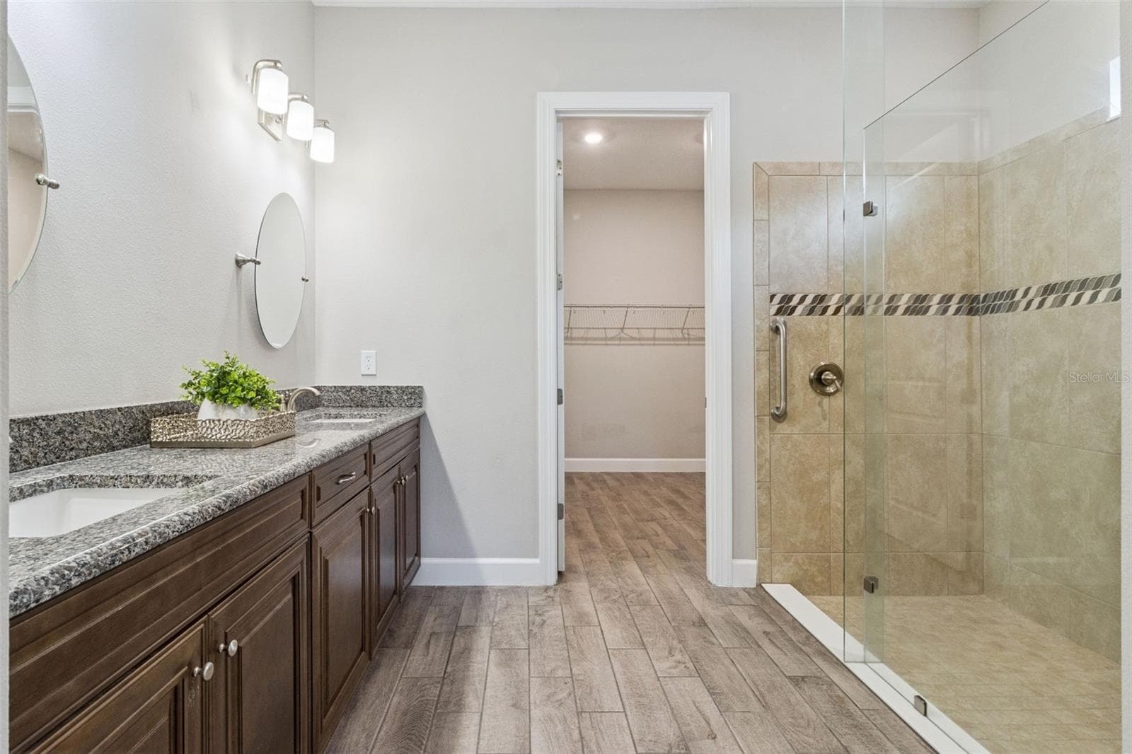 Second primary bathroom with granite vanity, tiled walk in shower, and walk in closet. - 4108 VIA TOLEDO CT, POINCIANA