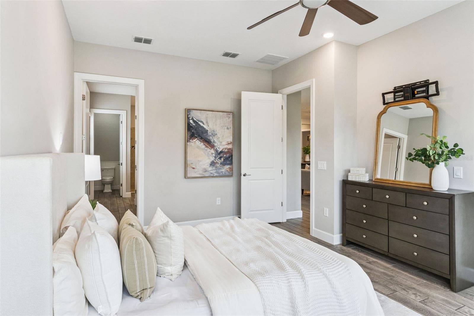 First primary bedroom with dresser area, ceiling fan, and generous space. - 4108 VIA TOLEDO CT, POINCIANA