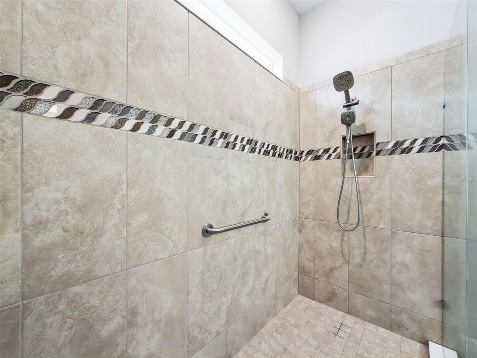 Oversized tiled walk in shower with decorative accent band and glass door. - 4108 VIA TOLEDO CT, POINCIANA