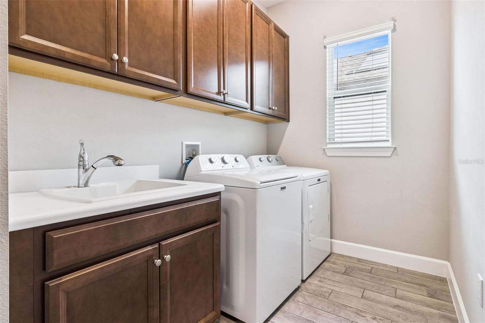 Indoor laundry room with upper cabinets, sink, and washer and dryer. - 4108 VIA TOLEDO CT, POINCIANA