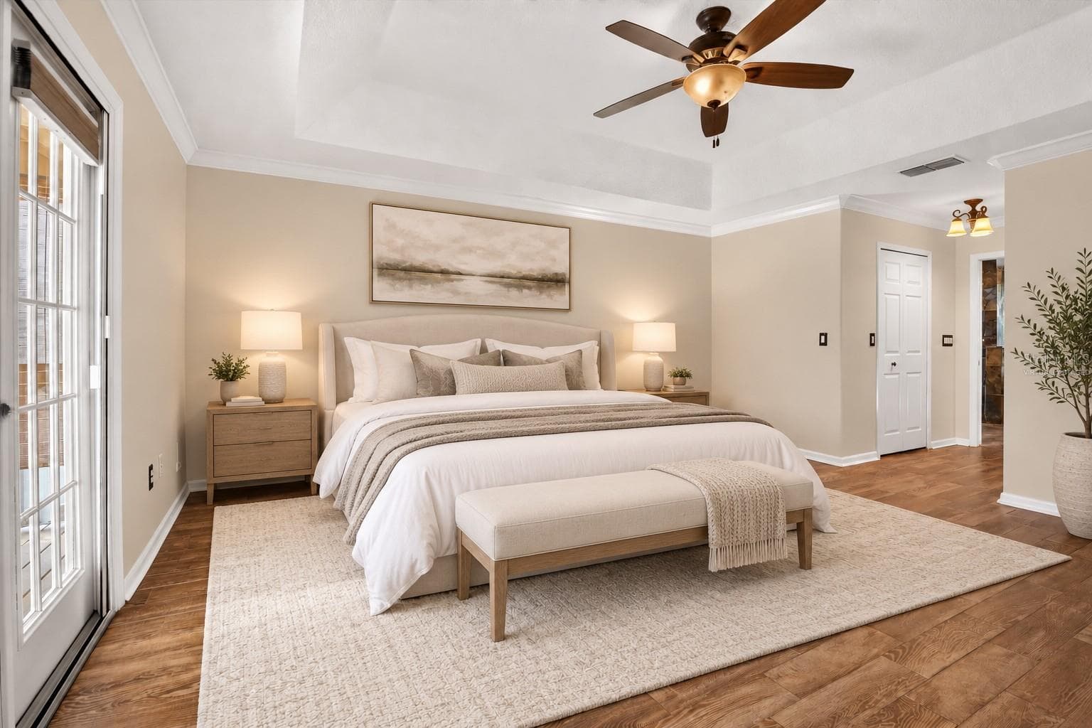 Virtually staged: Primary bedroom with a tray ceiling and wood flooring. - 2109 WEMBLEY PL, OVIEDO
