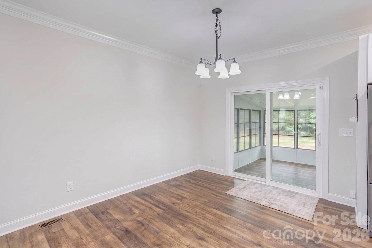Dining area overlooks sunroom in one direction and open living room area in the other direction. - 317 Oak Brook Drive, Salisbury