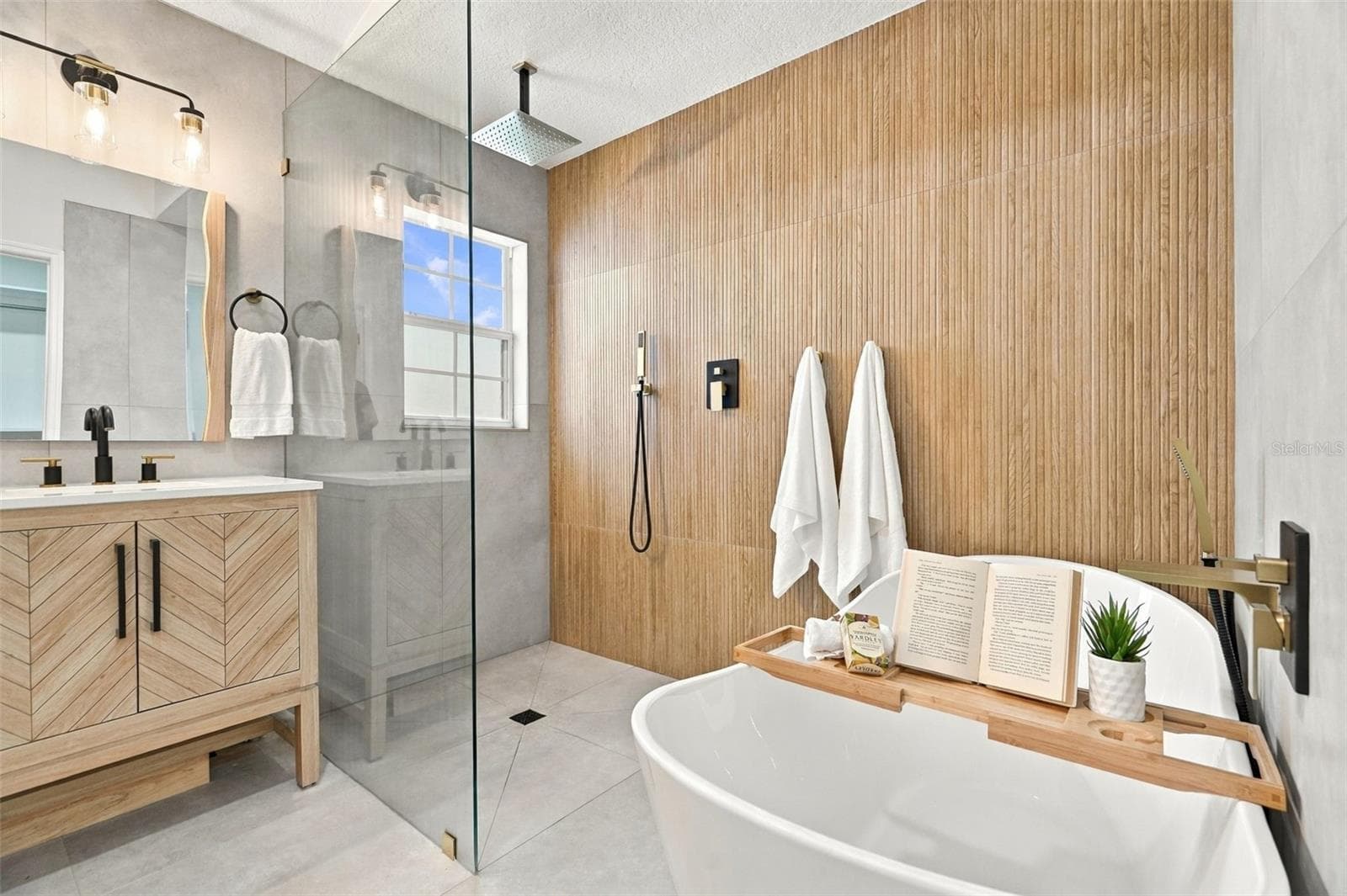 A frameless glass walk-in shower with a rainfall shower head system, a standalone soaking tub, and dual vanity sinks. - 625 FOLSOM ST S, ST PETERSBURG