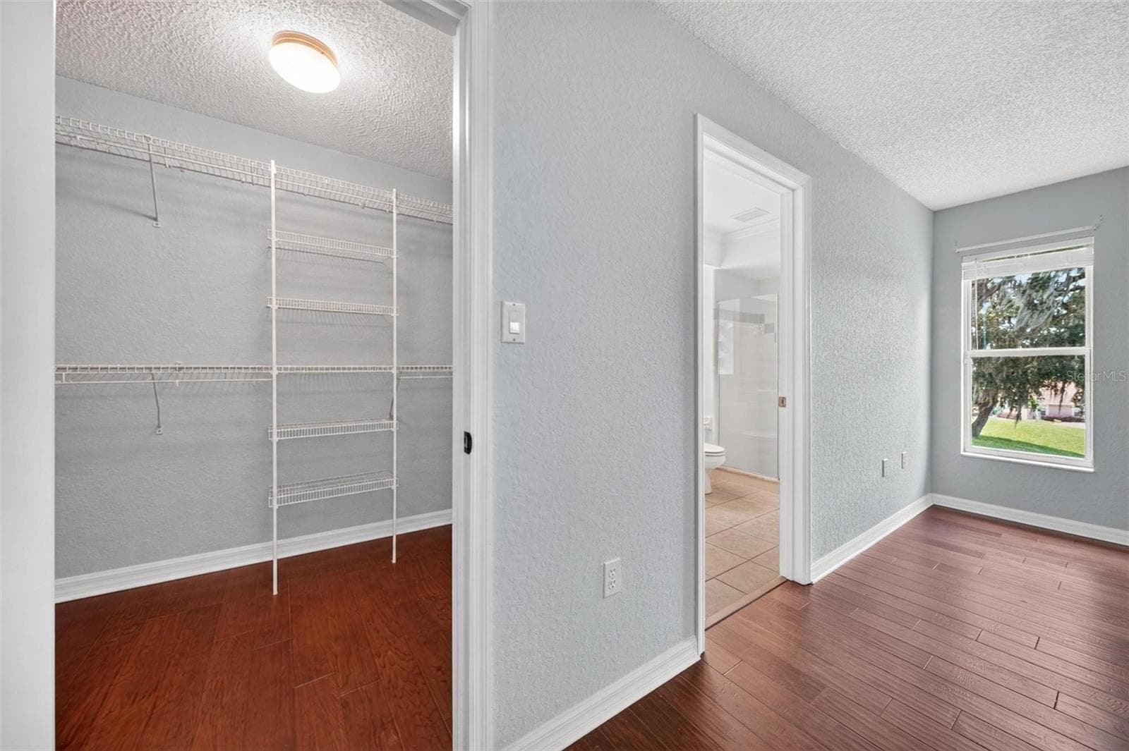 Primary bedroom walk in closet - 211 HANGING MOSS LN, LADY LAKE