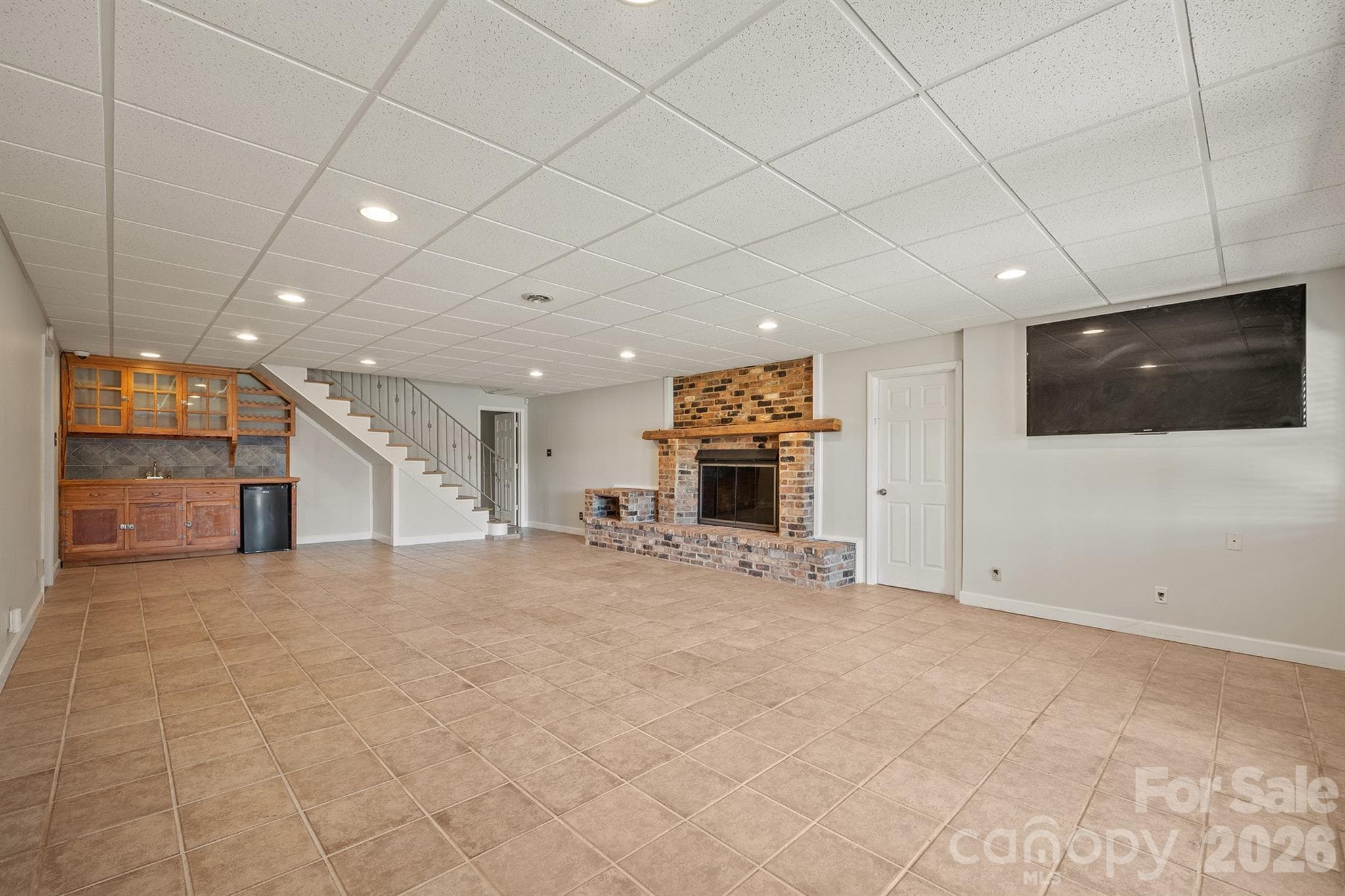 Wet bar and refrigerator are ready for you to make it your own, maybe paint the cabinets a dark color or restain them if you like the wood tones - 20919 Island Forest Drive, Cornelius