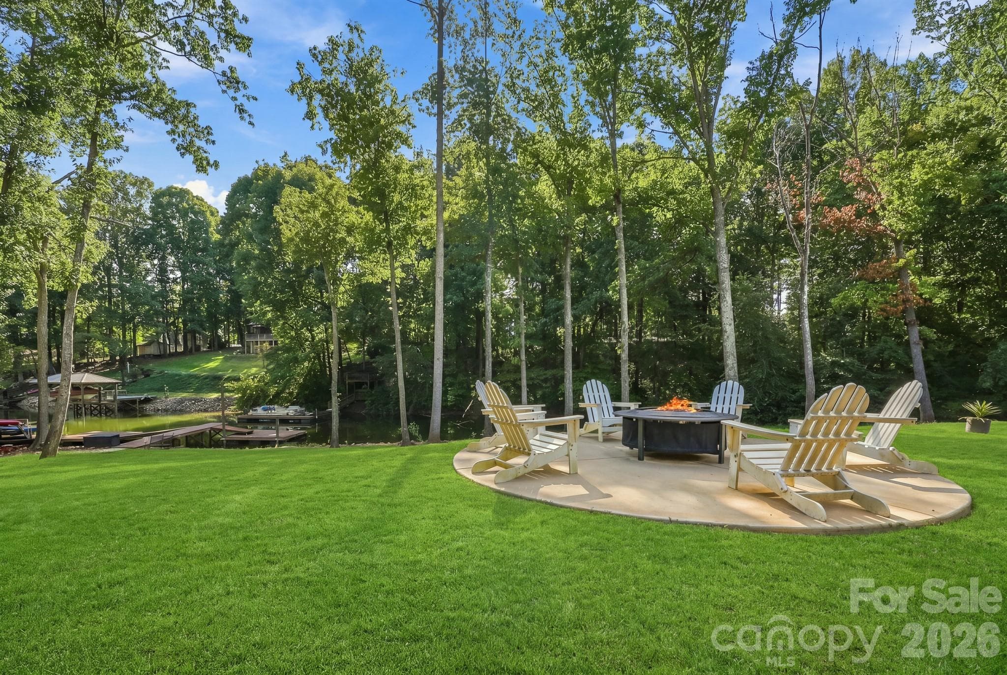 The expansive private lawn provides a wonderful place to play, and to gather around the fire pit as evening settles in and the sun sets over the water. - 143 Hideaway Lane, Mooresville
