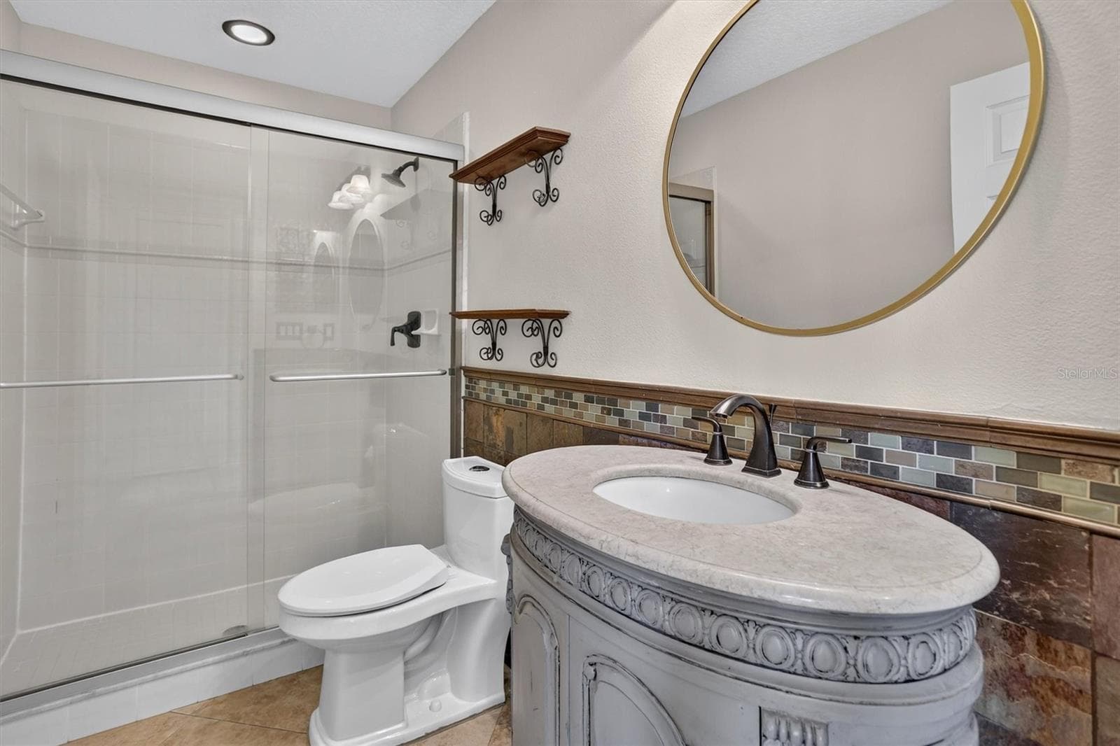 1st floor Bathroom with a round mirror and vanity. - 2109 WEMBLEY PL, OVIEDO