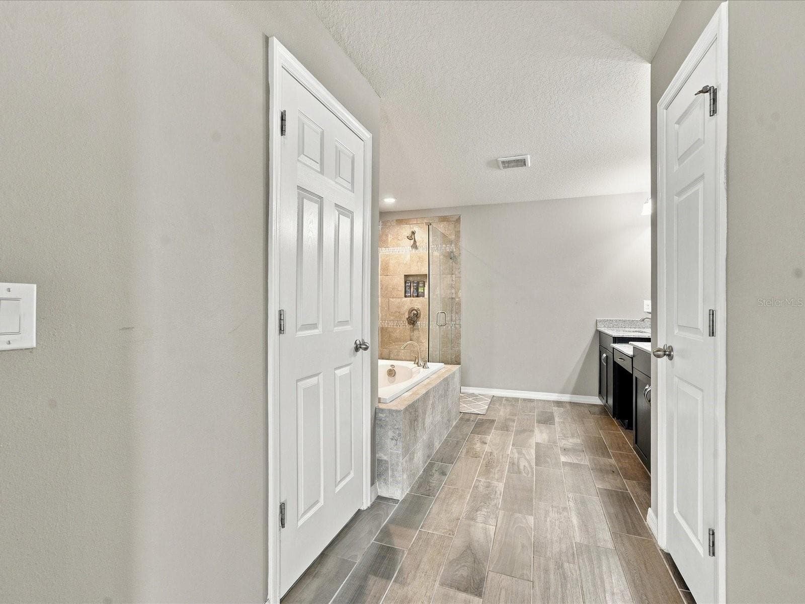 Primary bathroom with linen closet, private water closet, dual vanity, garden tub and walk in shower. - 18901 CORNUTA ST, LUTZ