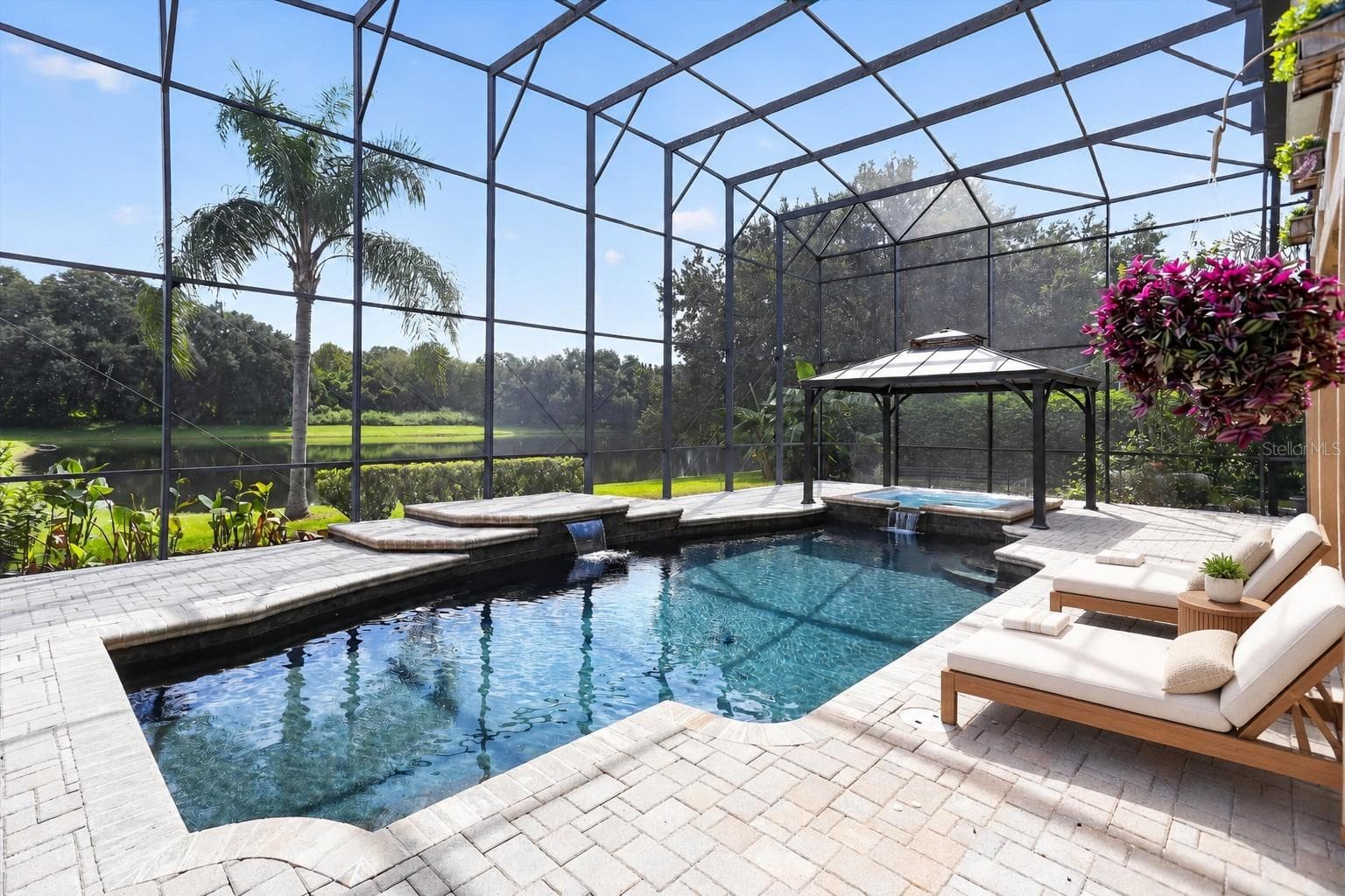 Private saltwater pool within an expansive screened enclosure, with peaceful pond views beyond. - 2109 WEMBLEY PL, OVIEDO