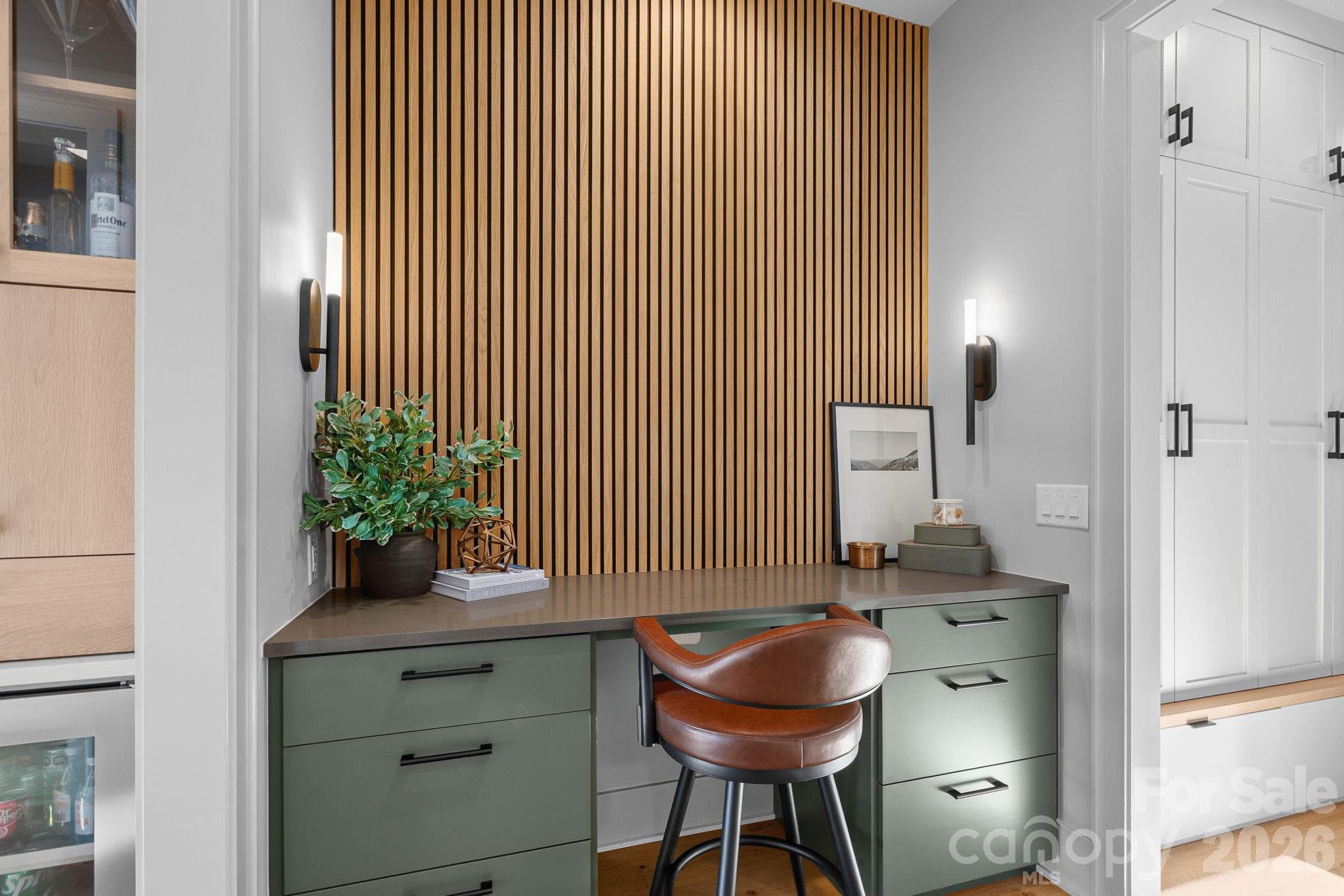 Thoughtfully designed built-in workspace with custom cabinetry and a warm architectural wood-slat accent wall. - 17811 Largo Place, Cornelius