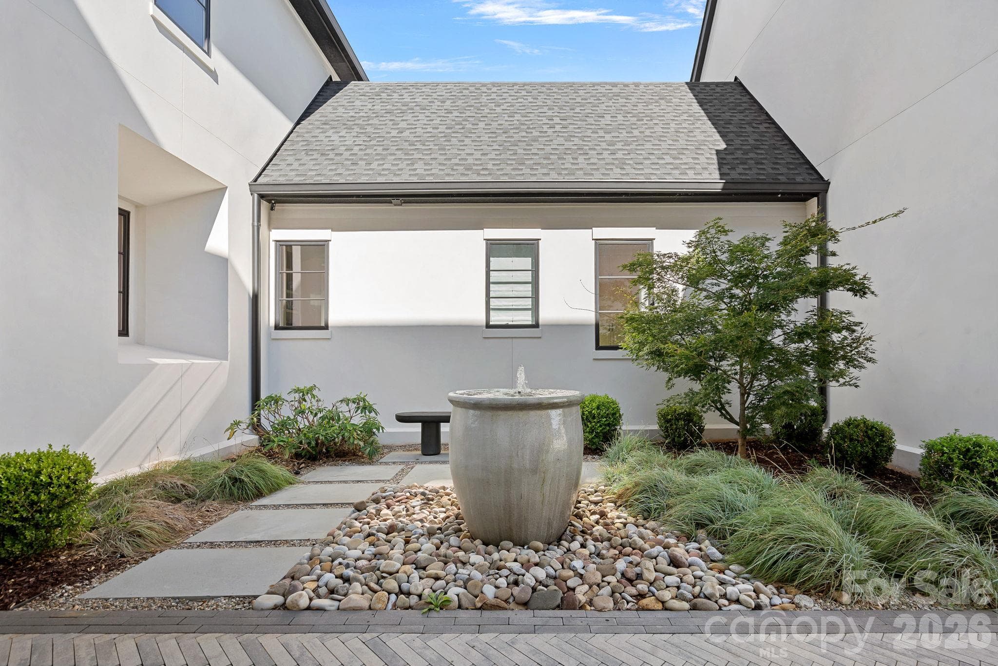 Tranquil garden courtyard with sculptural fountain and thoughtfully curated landscaping. - 17811 Largo Place, Cornelius