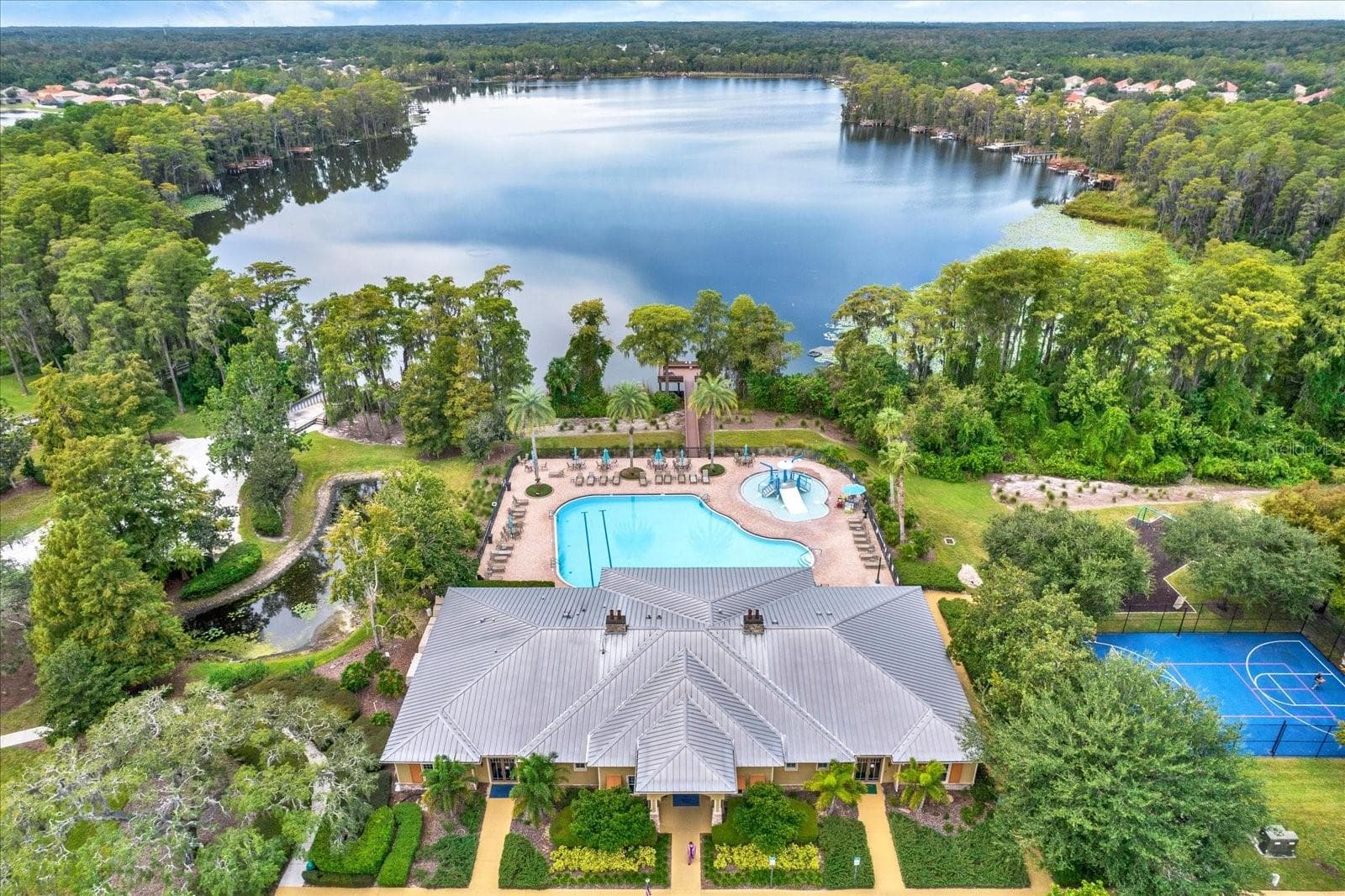 Aerial view of the Waters Ede clubhouse, community pool, and lake - 8538 REEDVILLE ST, NEW PORT RICHEY