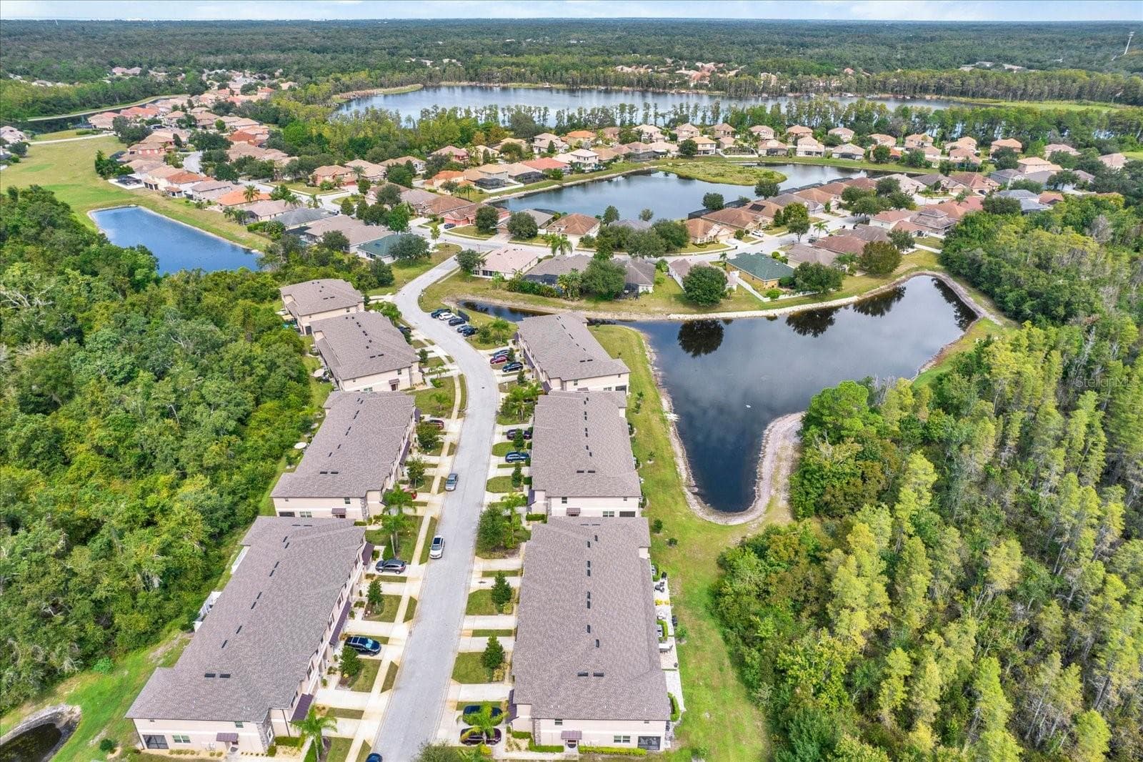 Aerial view of Ventana at Waters Edge with ponds and the lake beyond - 8538 REEDVILLE ST, NEW PORT RICHEY