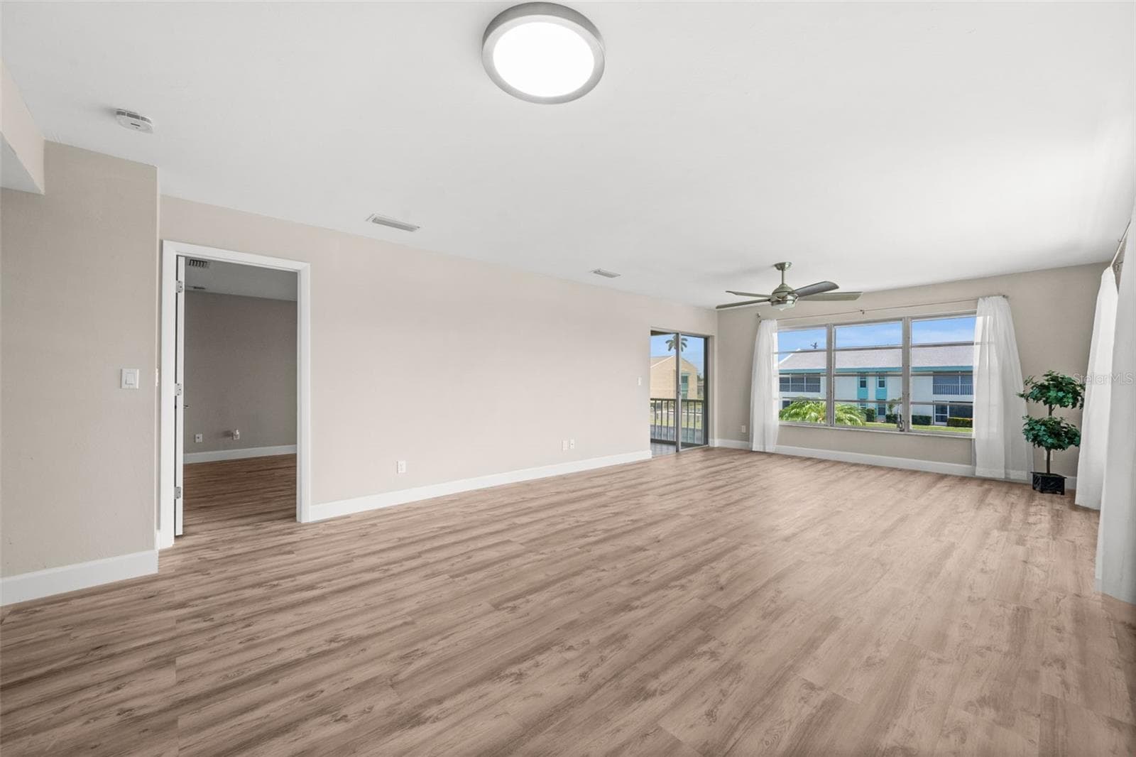 Living Room with door to the Primary Suite to the left, and access to the lanai - 1345 SE 40TH TER #2E, CAPE CORAL