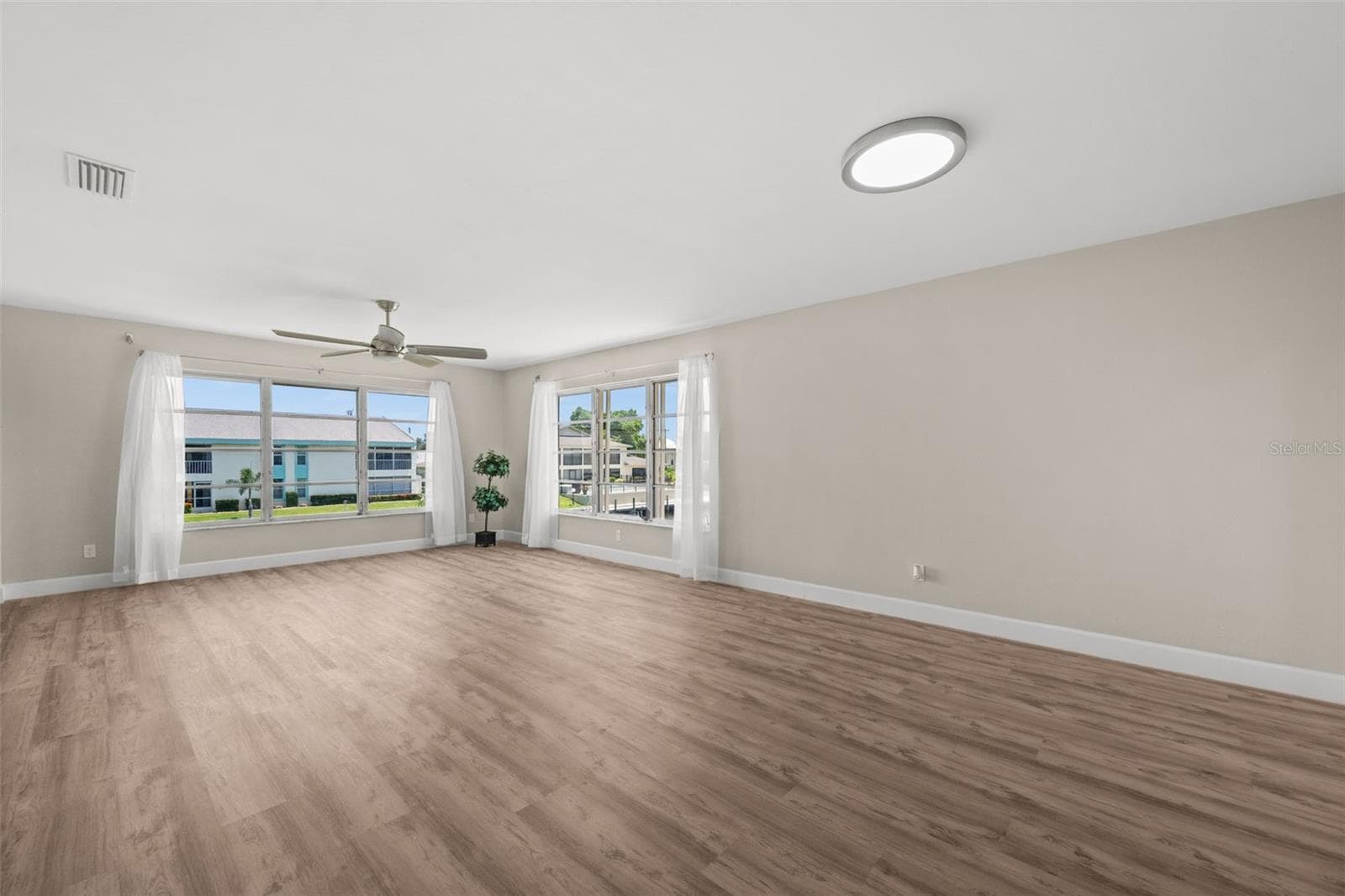 Living Room has tons of natural light from the corner windows that overlook the pool and canal - 1345 SE 40TH TER #2E, CAPE CORAL