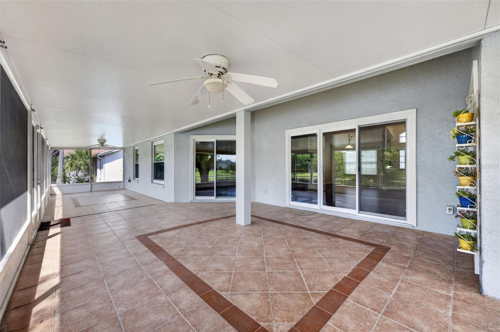 Back Patio with sliders from the living room, family room, and primary retreat. - 2925 EAGLE LAKE DR, ORLANDO
