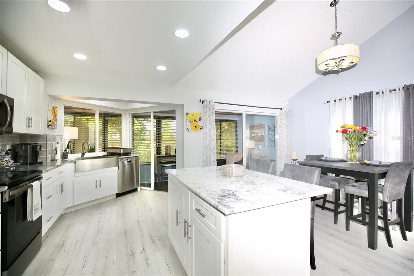 kitchen island, dining area and double doors to the indoor setting area - 3540 COUNTRYBROOK LN #16, PALM HARBOR