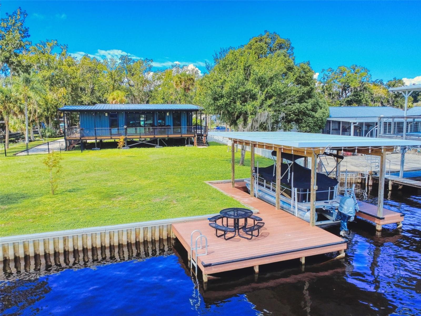 homes and dock, sea wall from riverview - 56108 SAWGRASS RD, ASTOR