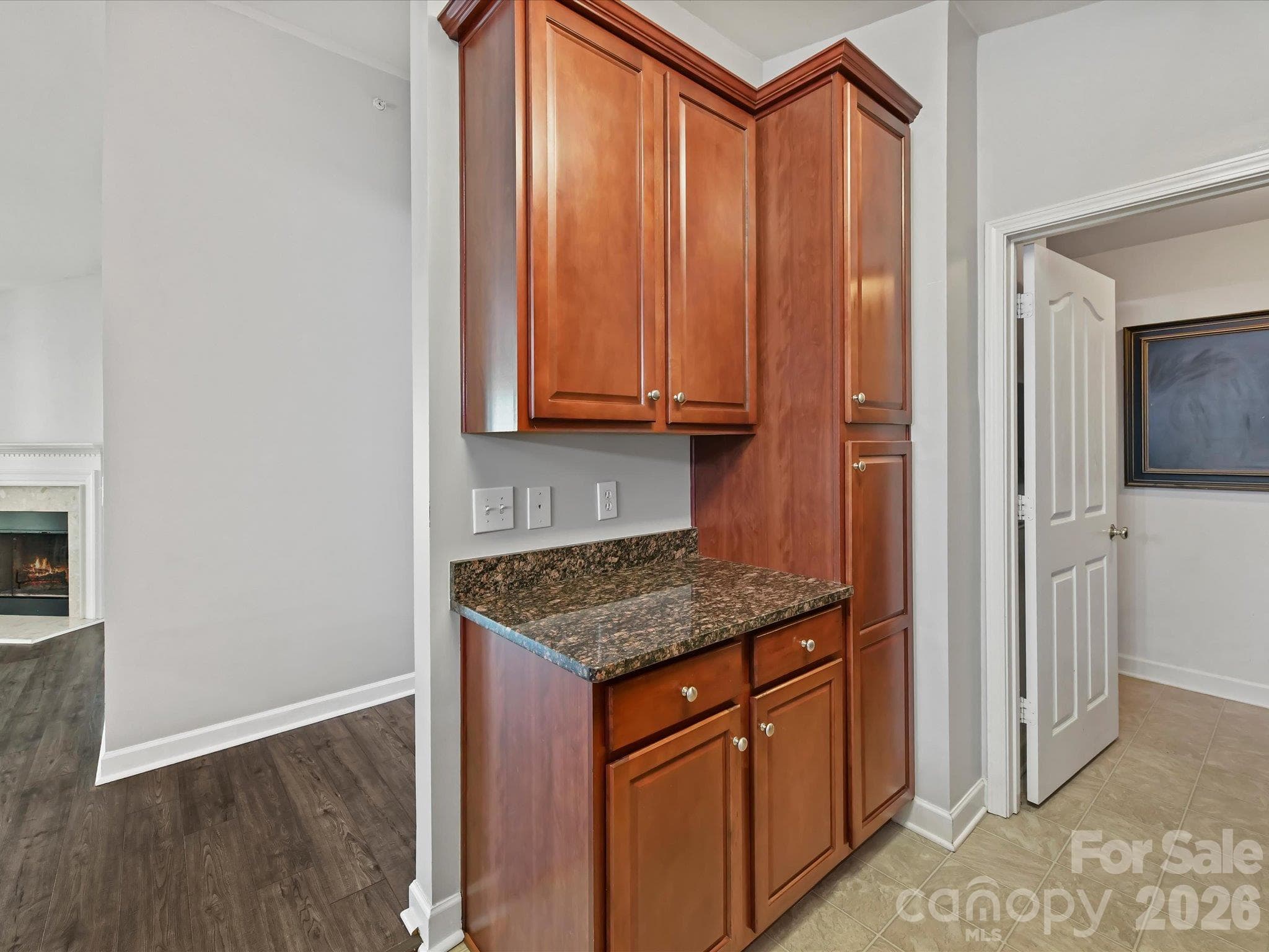 Well-appointed kitchen featuring rich wood cabinetry, granite countertops, stainless steel appliances, generous storage, and a convenient breakfast bar opening to the main living areas. - 9031 Mcdowell Creek Court, Cornelius