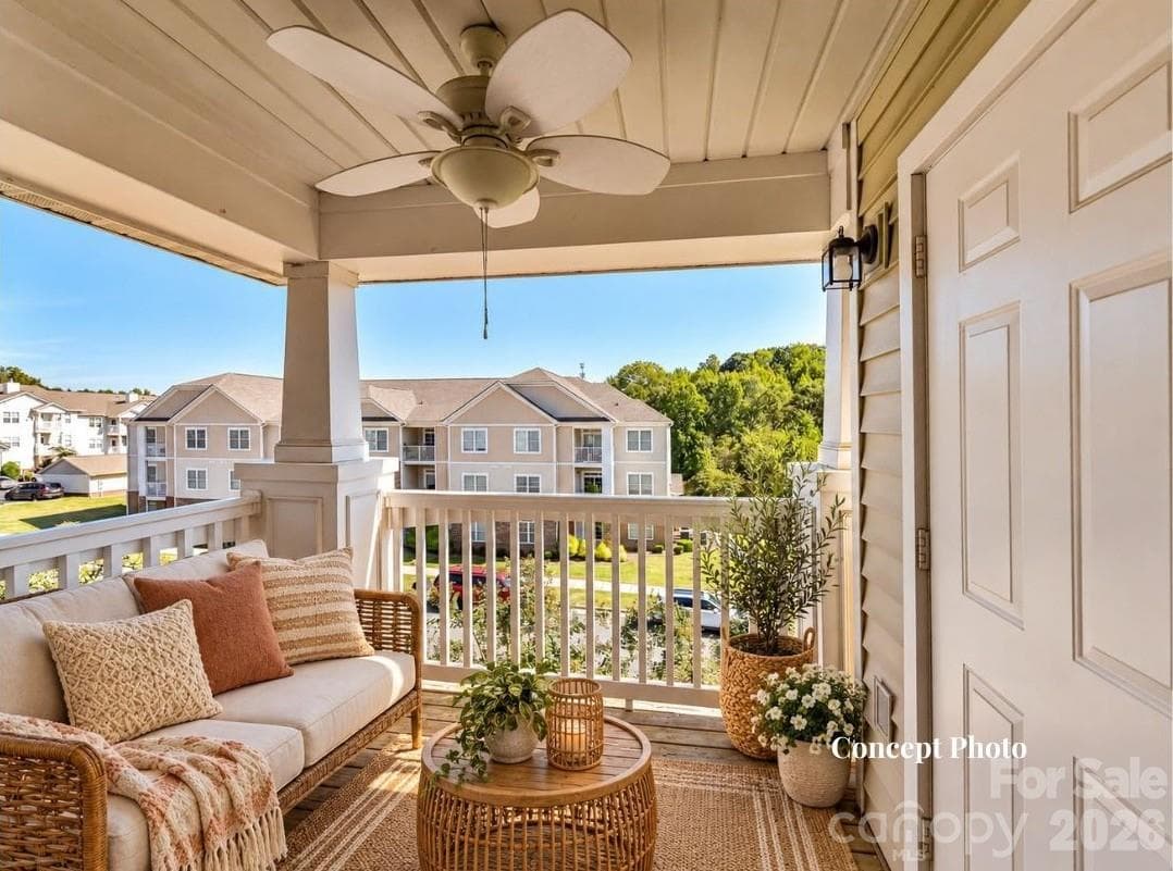 Virtually staged Covered balcony featuring a ceiling fan, outdoor seating, and an elevated view overlooking the surrounding community and mature greenery. - 9031 Mcdowell Creek Court, Cornelius