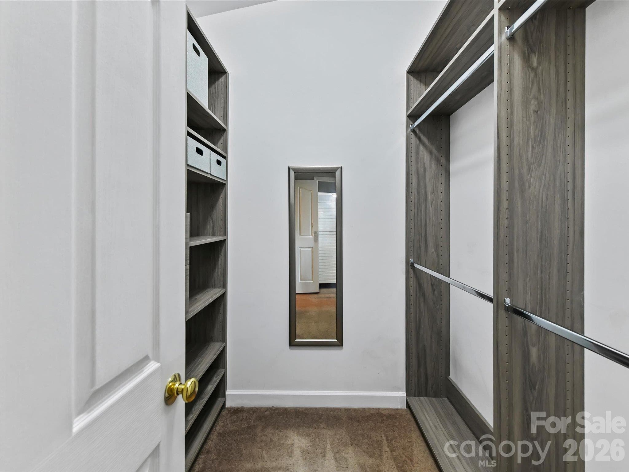 Spacious primary walk-in closet featuring a custom organization system with built-in shelving, multiple hanging areas, and generous storage space. - 9031 Mcdowell Creek Court, Cornelius