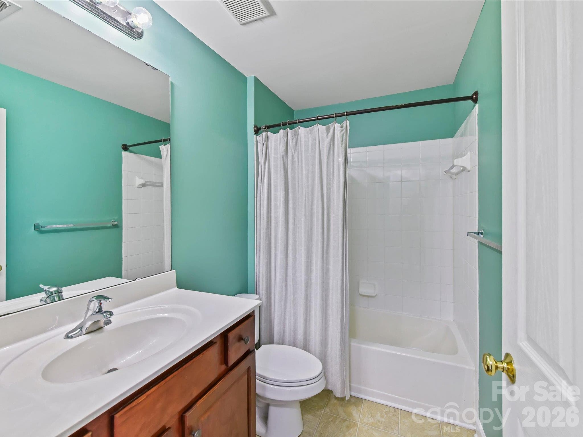 Full bath featuring a spacious vanity, large mirror, tub/shower combination with tile surround, and a bright, functional layout. - 9031 Mcdowell Creek Court, Cornelius