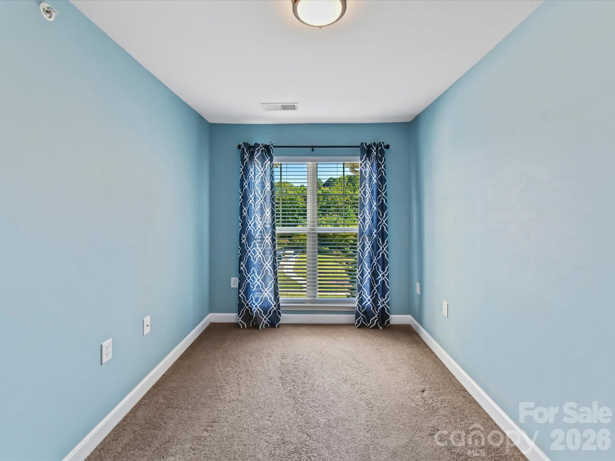 Versatile flex room featuring plush carpeting, abundant natural light, and French-door entry—ideal for a home office, guest space, or hobby room. - 9031 Mcdowell Creek Court, Cornelius