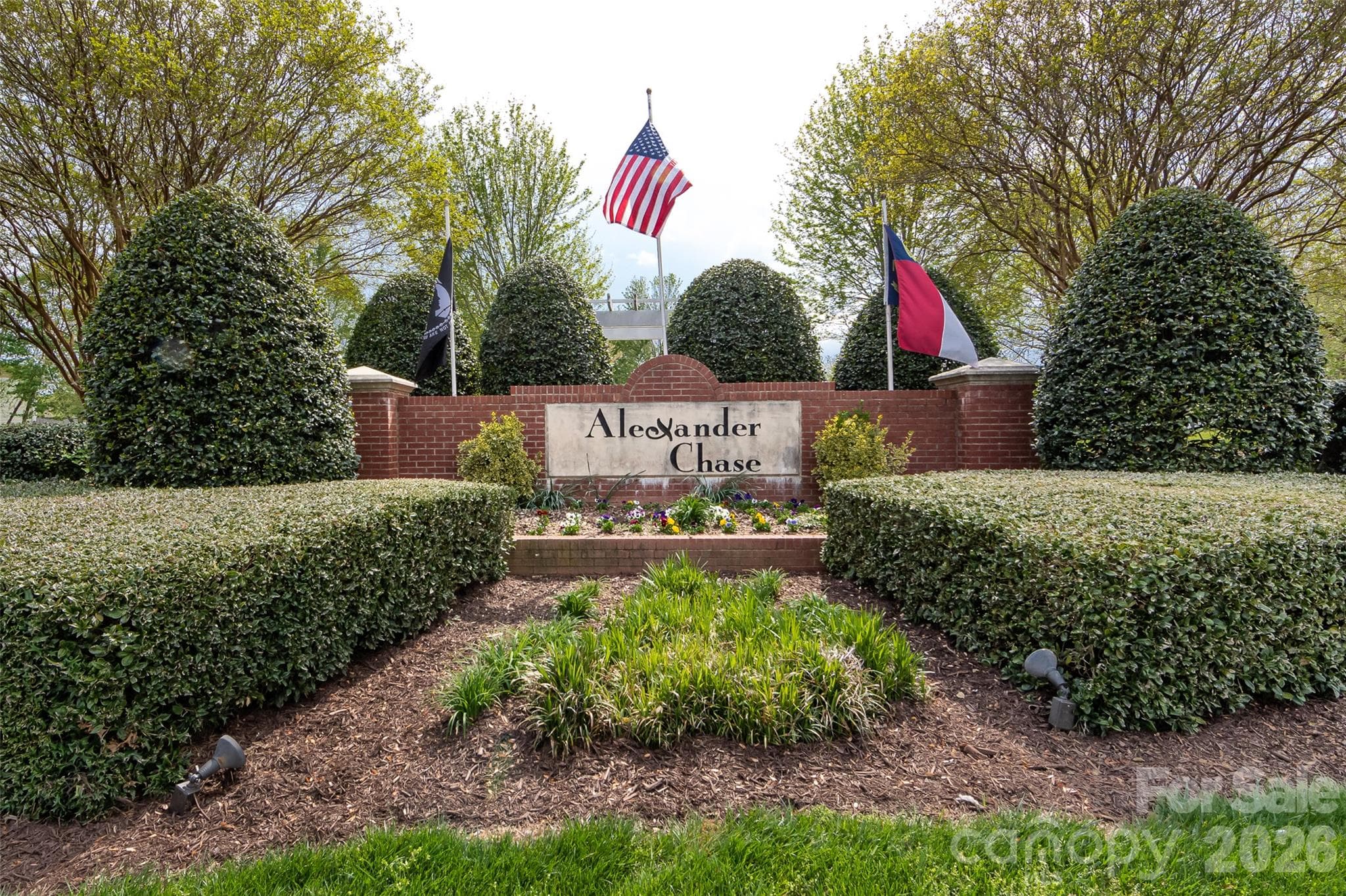 Welcoming entrance to the Alexander Chase community featuring attractive brick signage, mature landscaping, and beautifully maintained grounds. - 9031 Mcdowell Creek Court, Cornelius