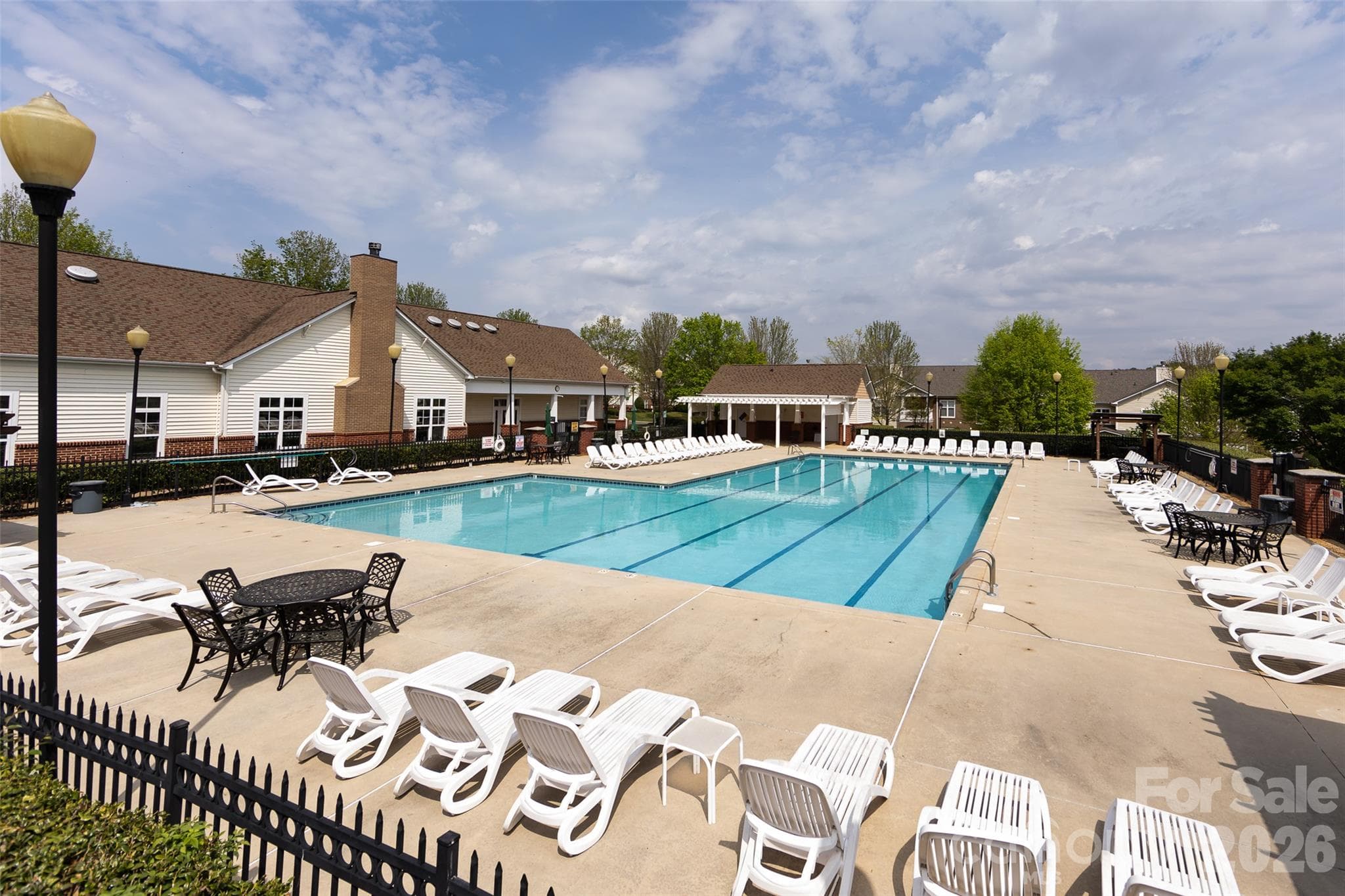 Community amenities include a spacious outdoor swimming pool with abundant lounge seating and a welcoming poolside setting for relaxing and recreation. - 9031 Mcdowell Creek Court, Cornelius
