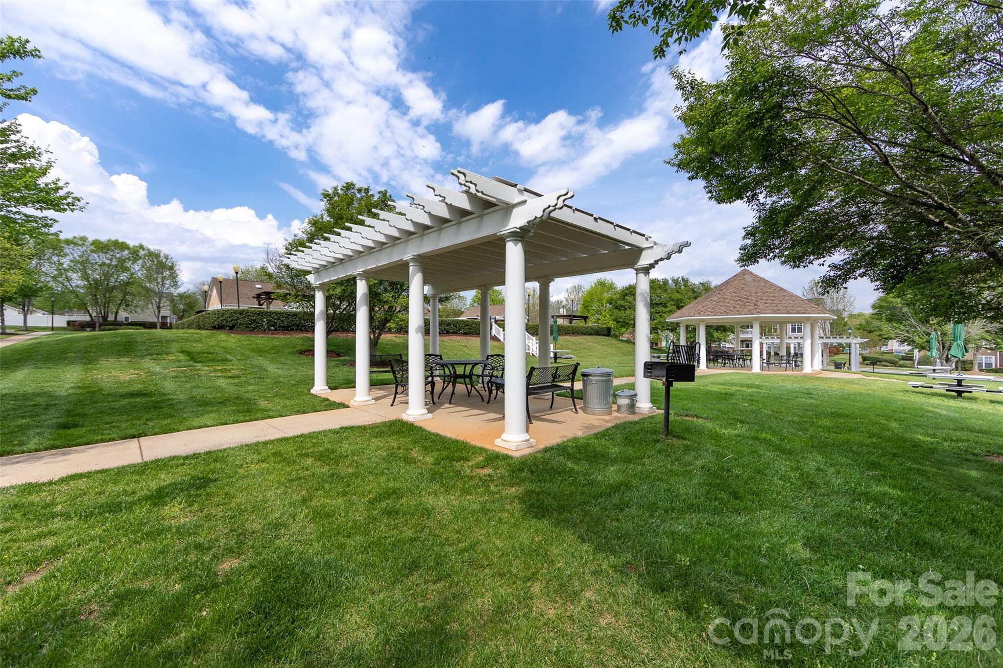 Community park featuring beautifully maintained green space, shaded seating areas, covered pavilions, and inviting outdoor gathering spaces. - 9031 Mcdowell Creek Court, Cornelius