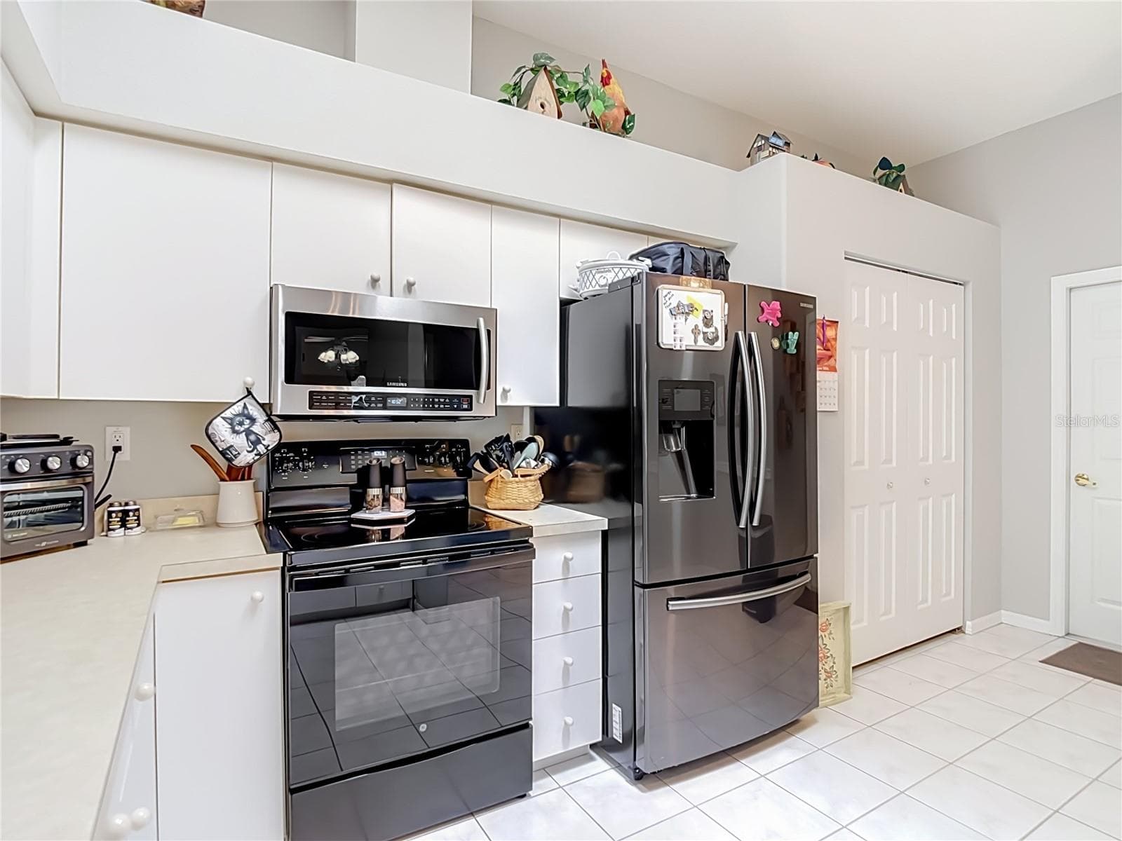 Kitche has newer appliances with a double door refrigerator and drawer freezer along with range and microwave. The door the right of refrigerator is a closet pantry for your groceries. The other door opens into the garage. - 13428 NORMAN CIR, HUDSON