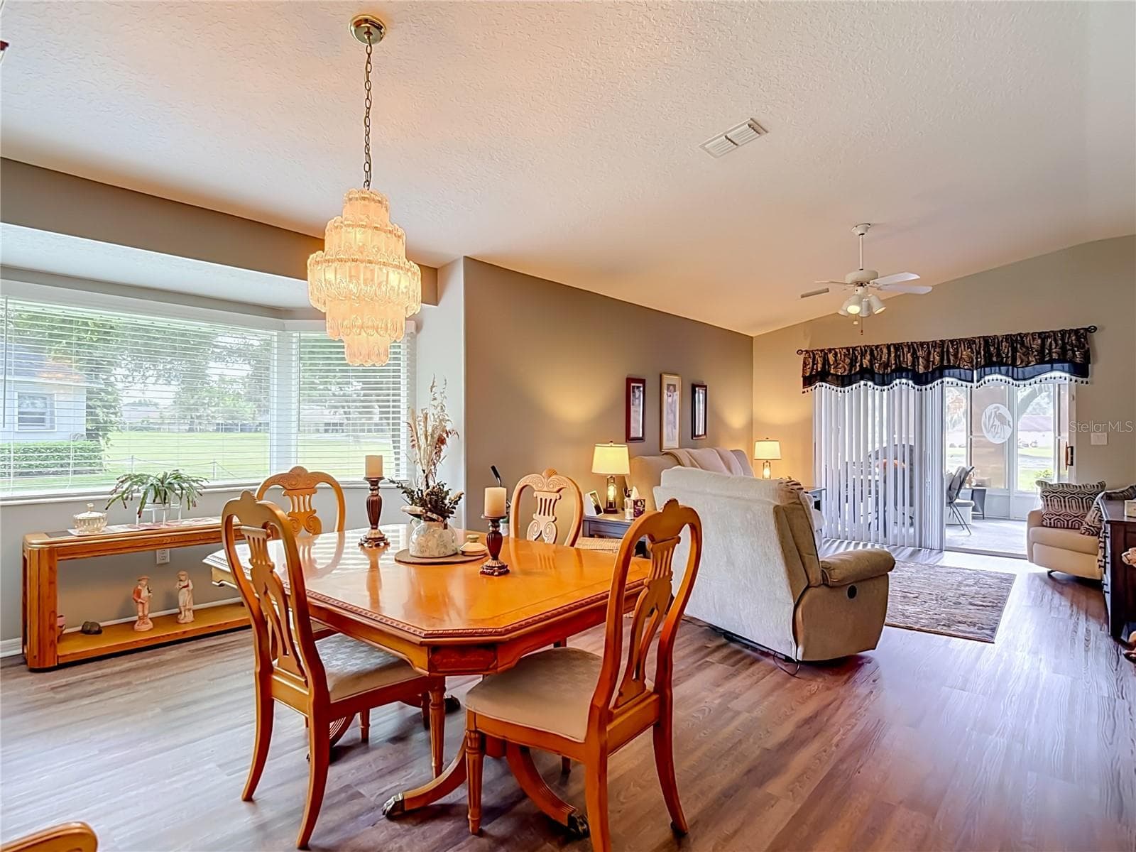 The dining area sits on luxury vinyl flooring . The bay windrow gives you a view of the 10th fairway. - 13428 NORMAN CIR, HUDSON