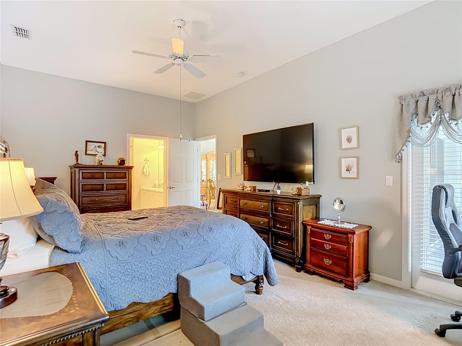 The primary bedroom sits on carpet and is located at the back of the villa. As you can see the room can accomdate quite a bit of bedroom furniture. - 13428 NORMAN CIR, HUDSON