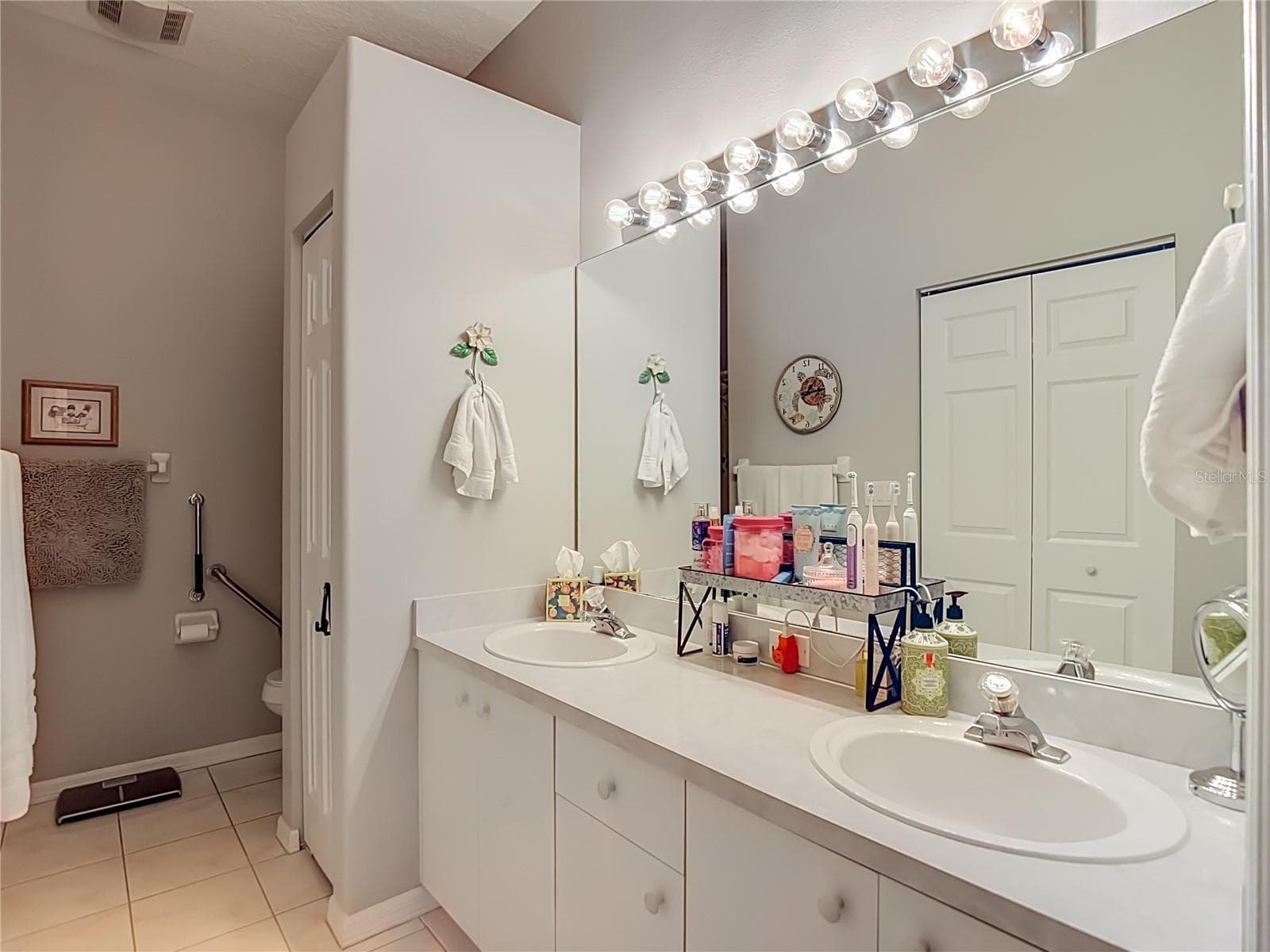 The primary bathroom has double sinks with a large mirror and linen closet for your bathing needs. - 13428 NORMAN CIR, HUDSON