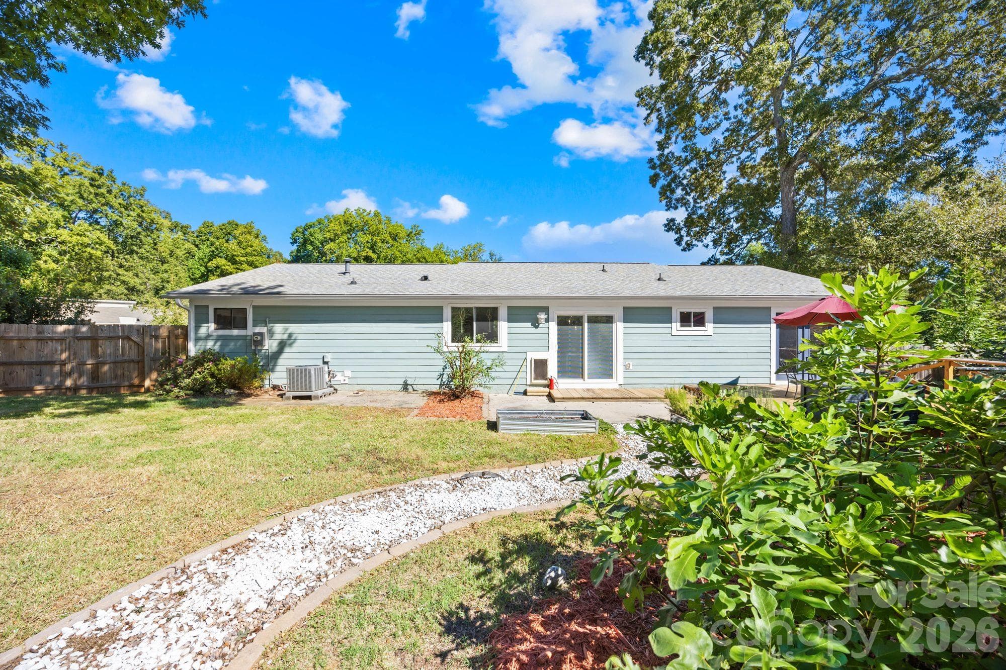 Rear exterior and backyard of this 1983 ranch home with a 2020 roof and fiber cement siding - 4900 Cricklewood Lane, Charlotte
