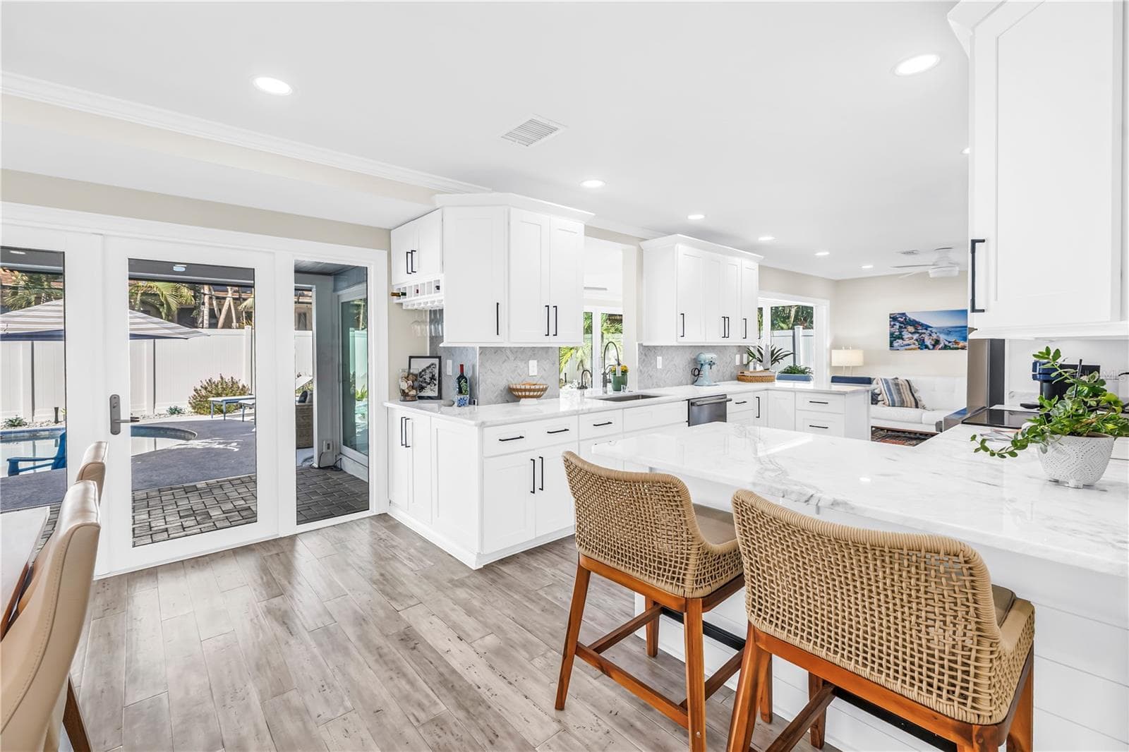 Casual seating to "help" the cook in this Showstopper Kitchen! Quartz countertops have a very light blue hue! - 1114 2ND AVE S, TIERRA VERDE