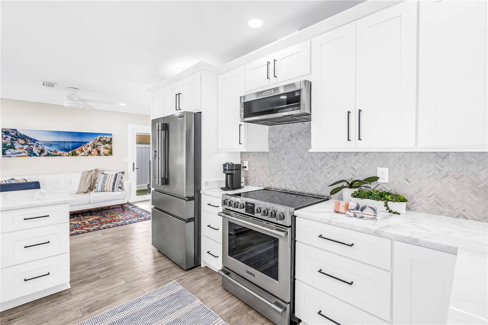 Stainless appliances, range with convection and air fryer functions, deep storage drawers and a herringbone shell tile backsplash. - 1114 2ND AVE S, TIERRA VERDE
