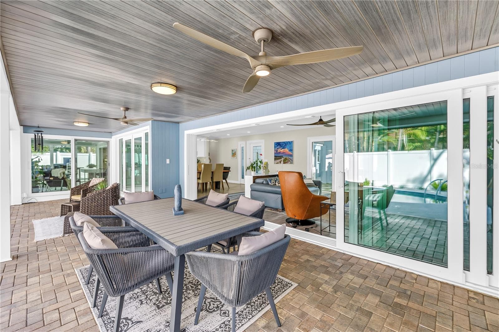 impact-rated pocket sliders disappear completely into the wall, dramatically opening the living room to the lanai and pool - 1114 2ND AVE S, TIERRA VERDE