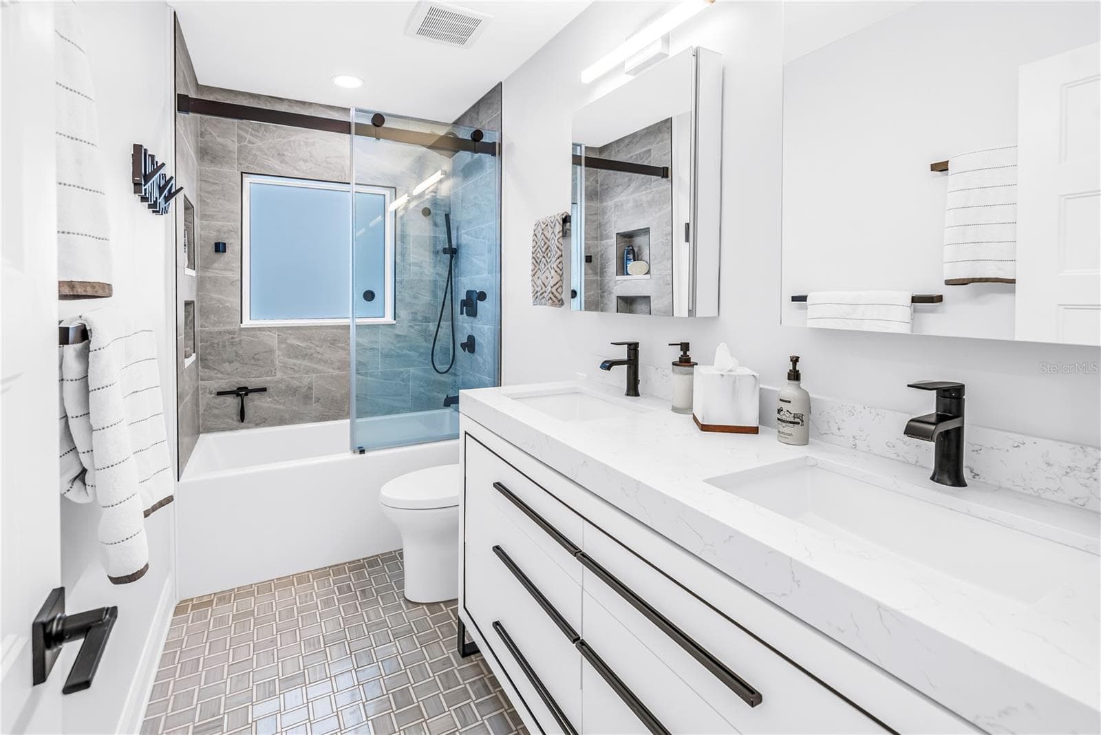 2nd bath with deep soaking tub, custom dual vanity with European style drawers, stone countertops, 2 Robern medicine cabinets, frosted glass window for natural light and comfort height European style flush toilet. - 1114 2ND AVE S, TIERRA VERDE