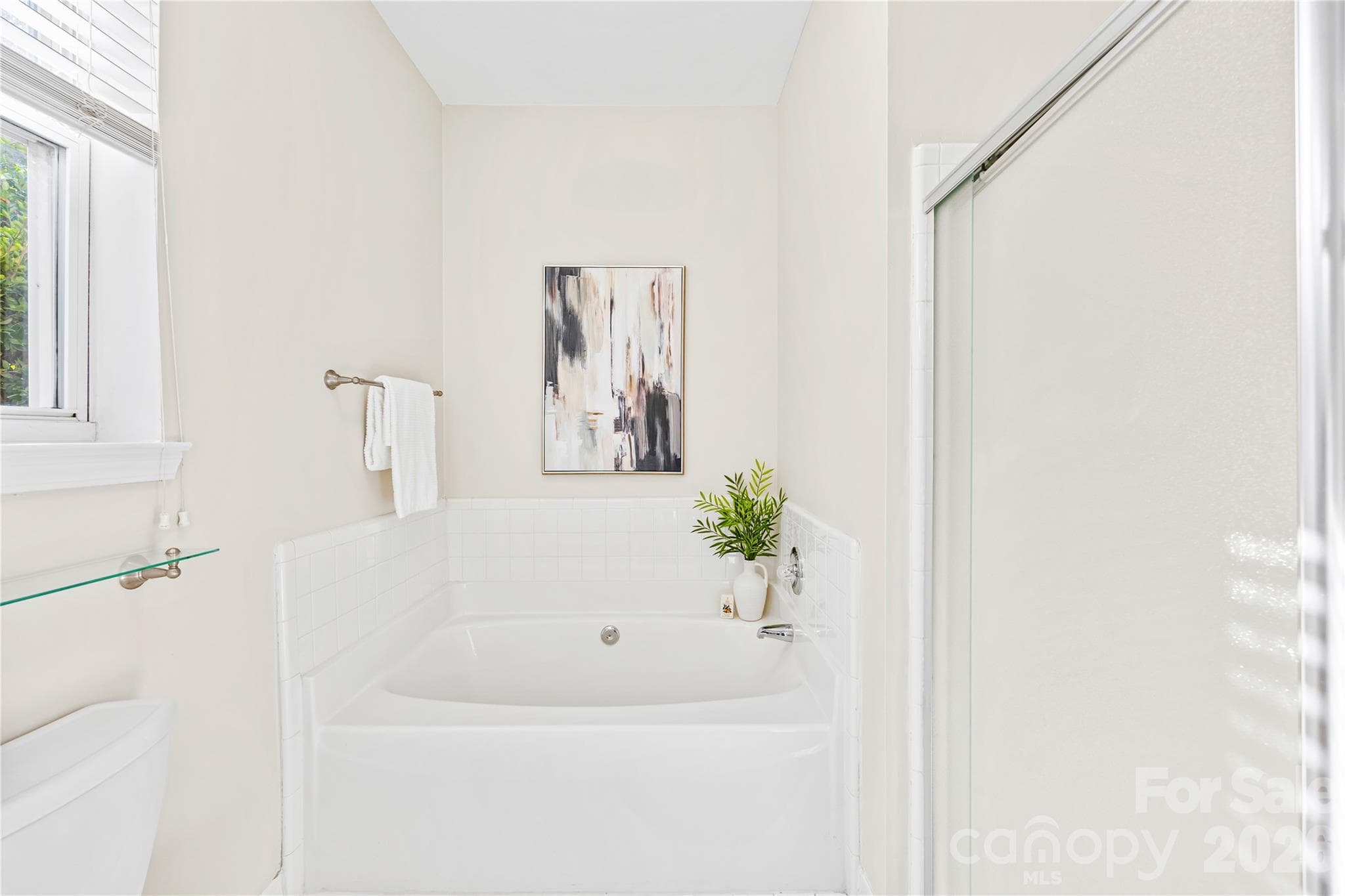 Relaxing primary en suite bathroom with soaking tub and walk-in shower. - 915 Northeast Drive, Davidson