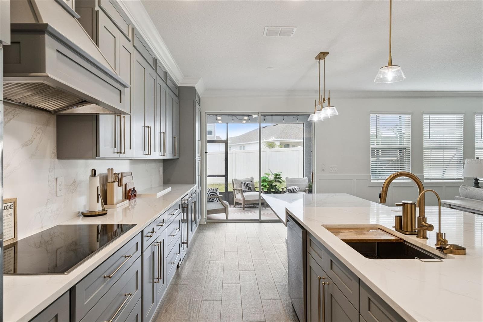 Marble backsplash, upgraded 36" smart induction cooktop with wifi and virtual flame technology, custom designer vent hood kitchen floor to ceiling custom cabinetry and fnishes , beautiful quartz counter tops - 6175 SHAVASANA RD RD, CLERMONT