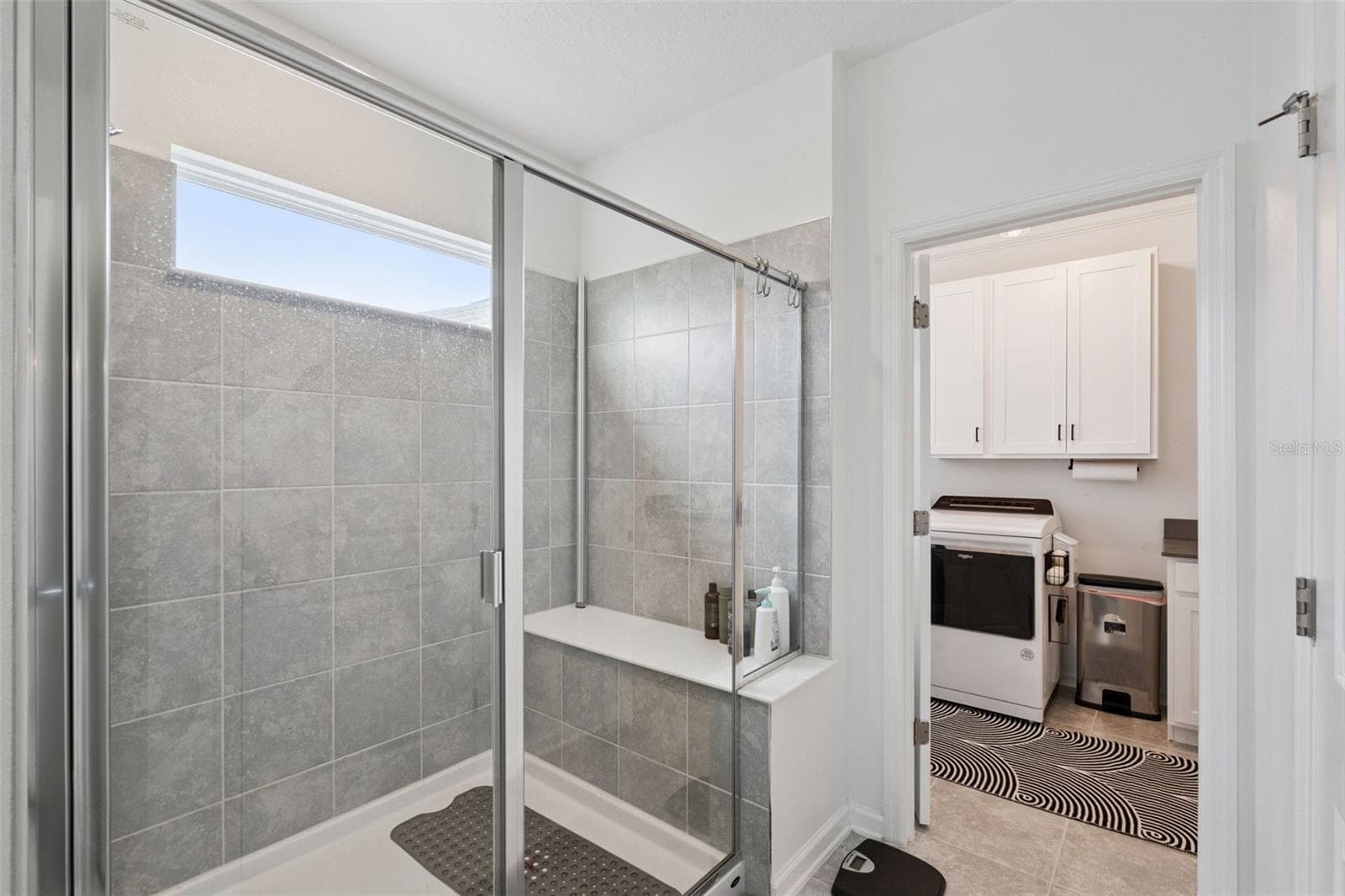 Owner's suite bathroom shower with built in seating, easy access into the laundry room - 6175 SHAVASANA RD RD, CLERMONT
