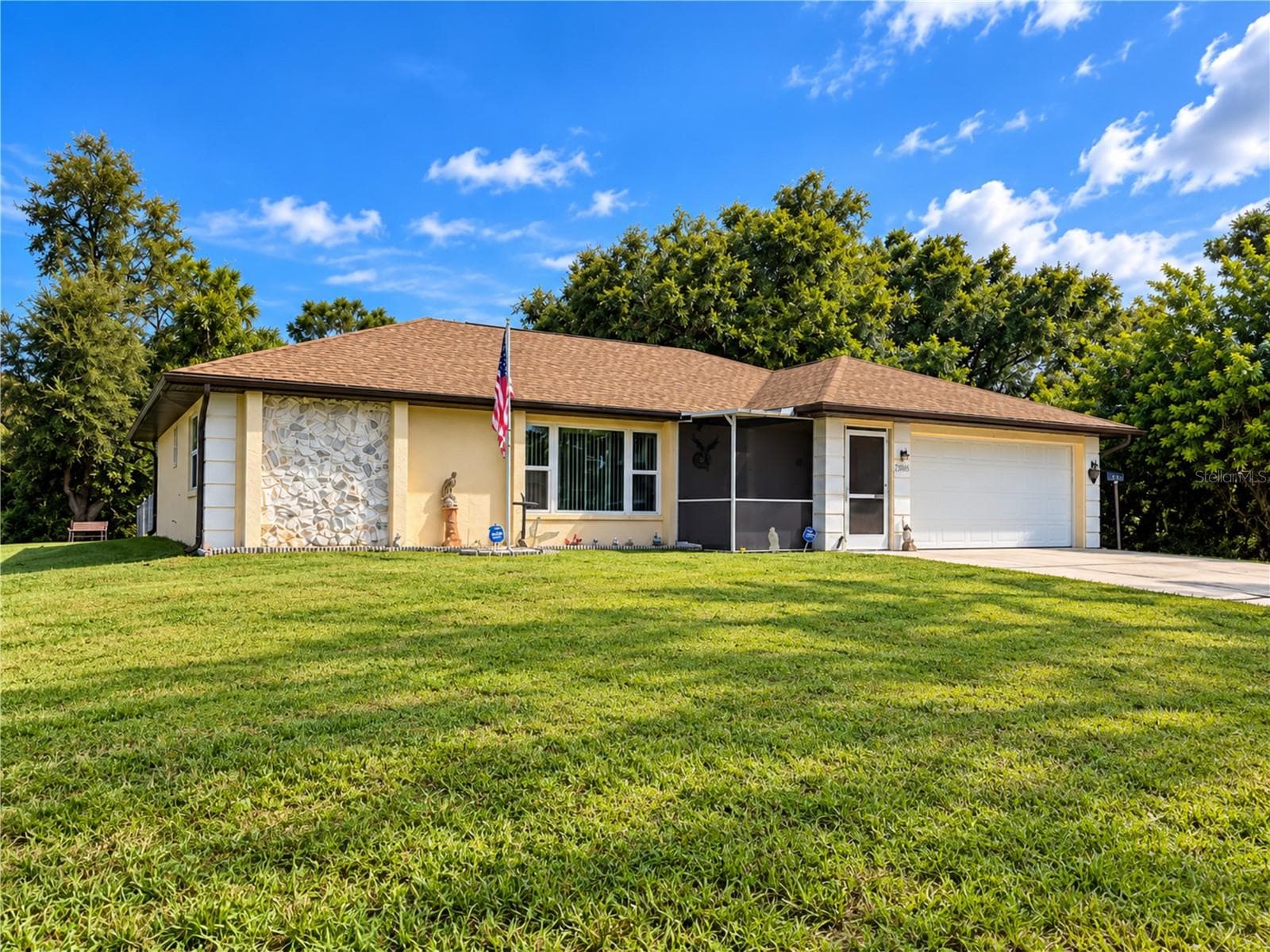 Front Exterior | Spacious front yard and attractive single story exterior with mature surroundings and plenty of driveway parking. - 23088 GRAY AVE, PORT CHARLOTTE