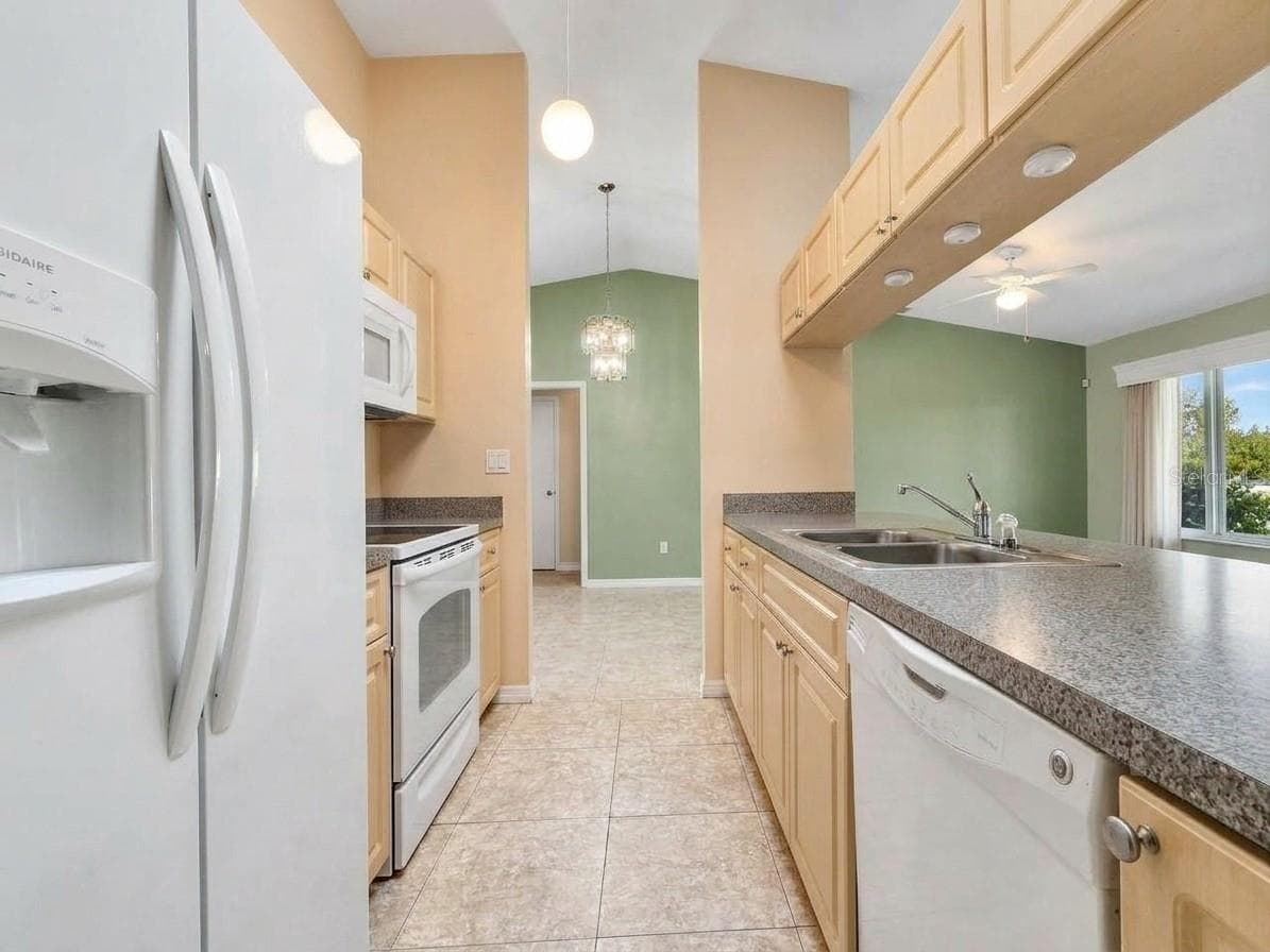 Kitchen | Kitchen offers generous cabinetry, countertop workspace, and convenient access to the surrounding living spaces. - 23088 GRAY AVE, PORT CHARLOTTE