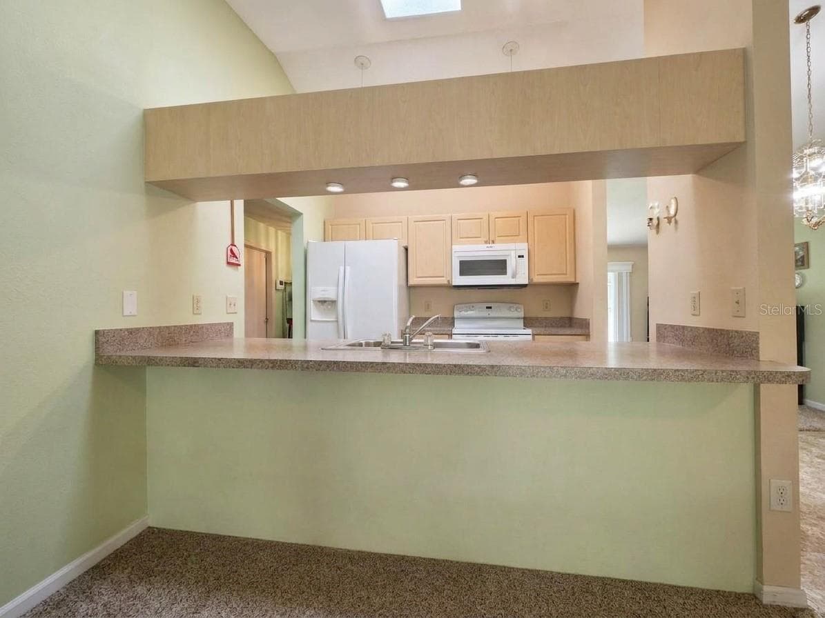 Kitchen | Another view showcasing the kitchen's functional layout, ample cabinetry, and center island. - 23088 GRAY AVE, PORT CHARLOTTE