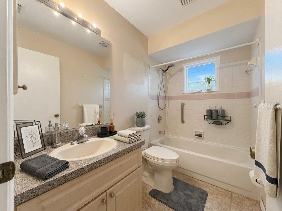 Guest Bathroom | Virtually Staged guest bathroom featuring a tub and shower combination with vanity storage. - 23088 GRAY AVE, PORT CHARLOTTE