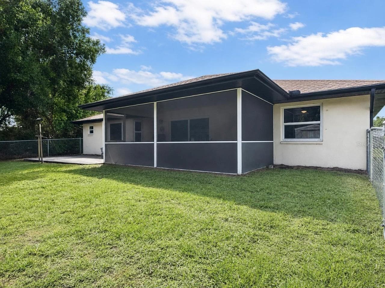 Rear Exterior | Extended paver patio provides additional outdoor living and entertaining space beyond the screened lanai. - 23088 GRAY AVE, PORT CHARLOTTE
