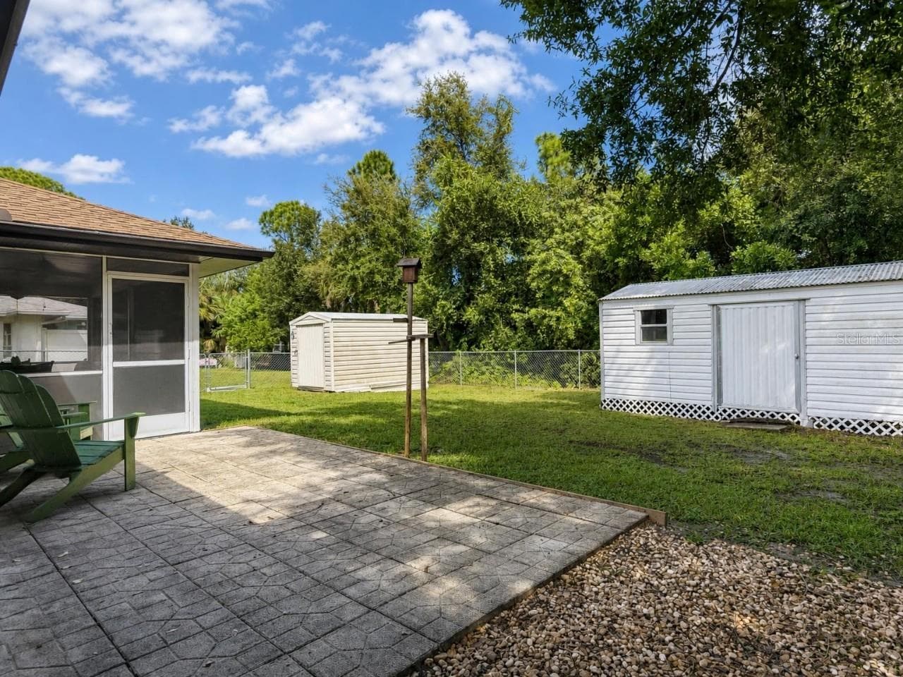 Backyard | Fully fenced backyard features mature landscaping and two storage sheds for tools, lawn equipment, and additional storage. - 23088 GRAY AVE, PORT CHARLOTTE