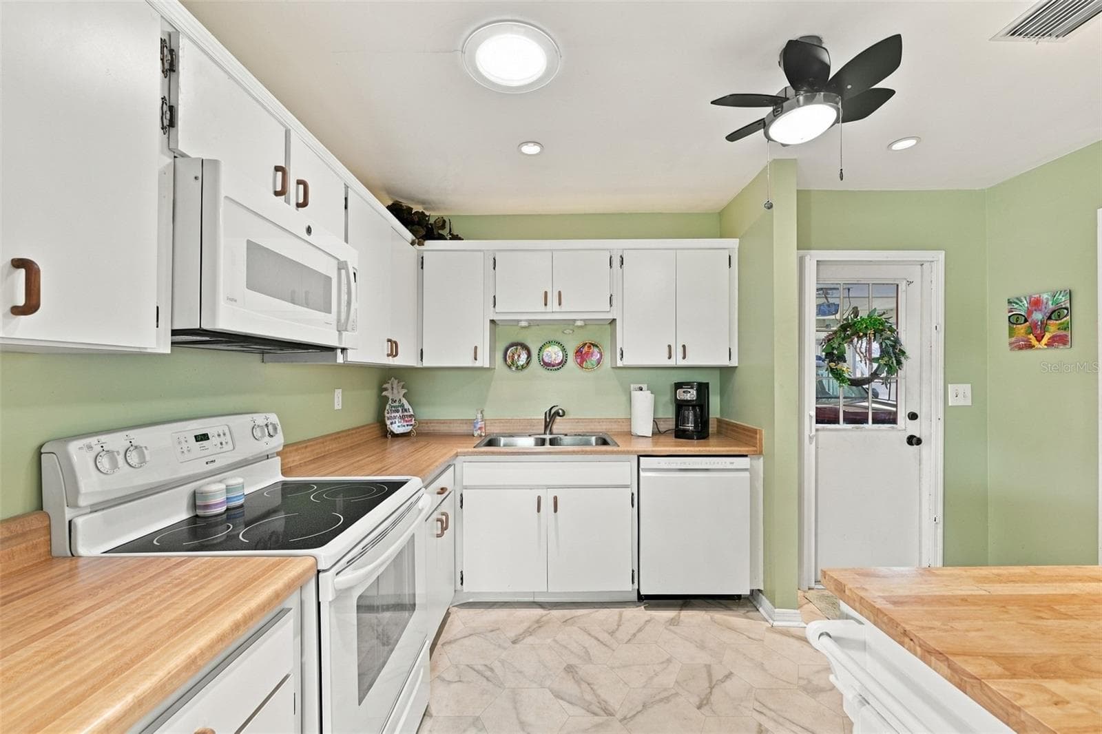 Butcher block counter tops and all appliances are nicely coordinated.  The solar tube allows natural sunshine into the kitchen. - 215 GENET CT, SUN CITY CENTER